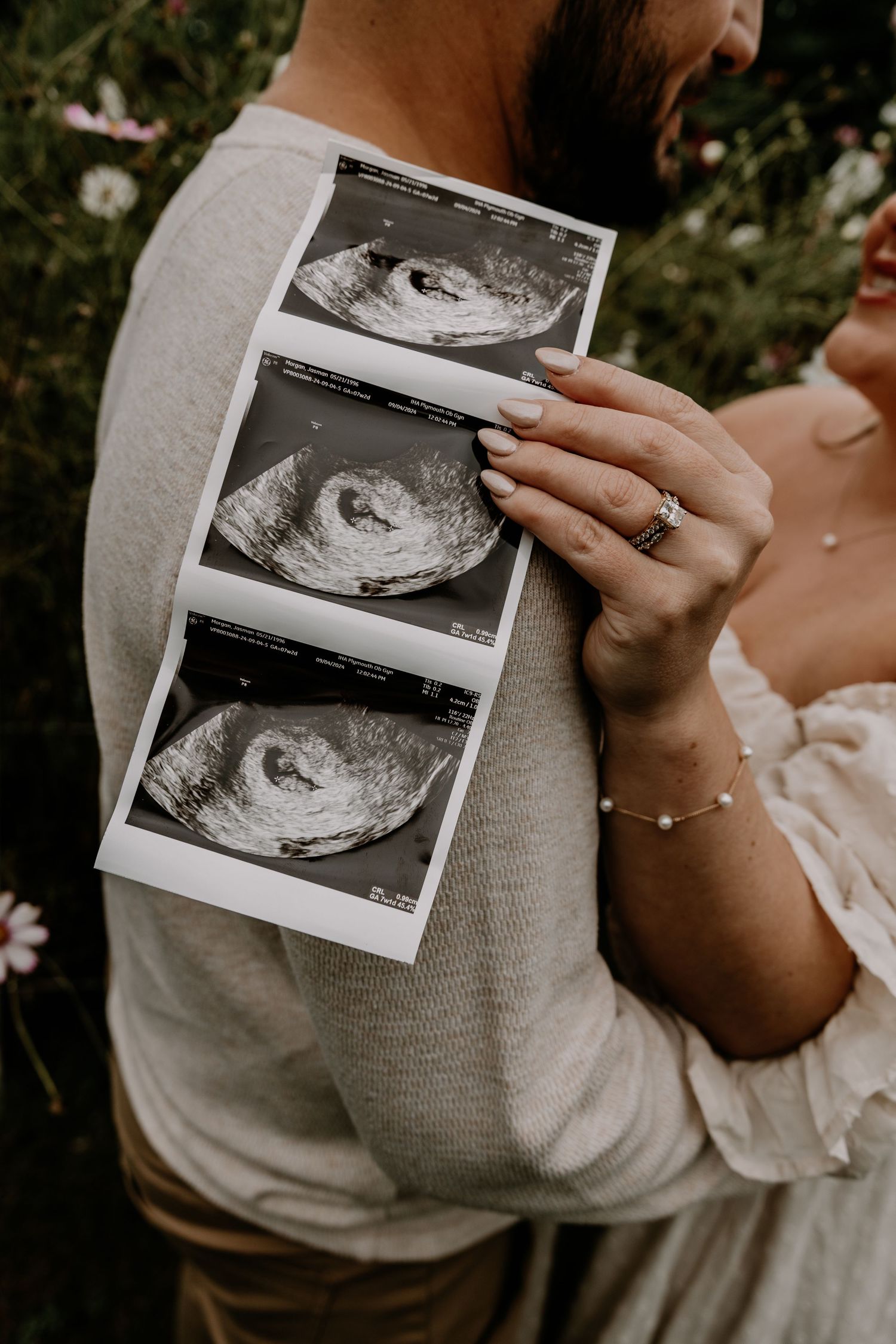 Close-up shots of hands holding black and white ultrasound images against floral backdrop.