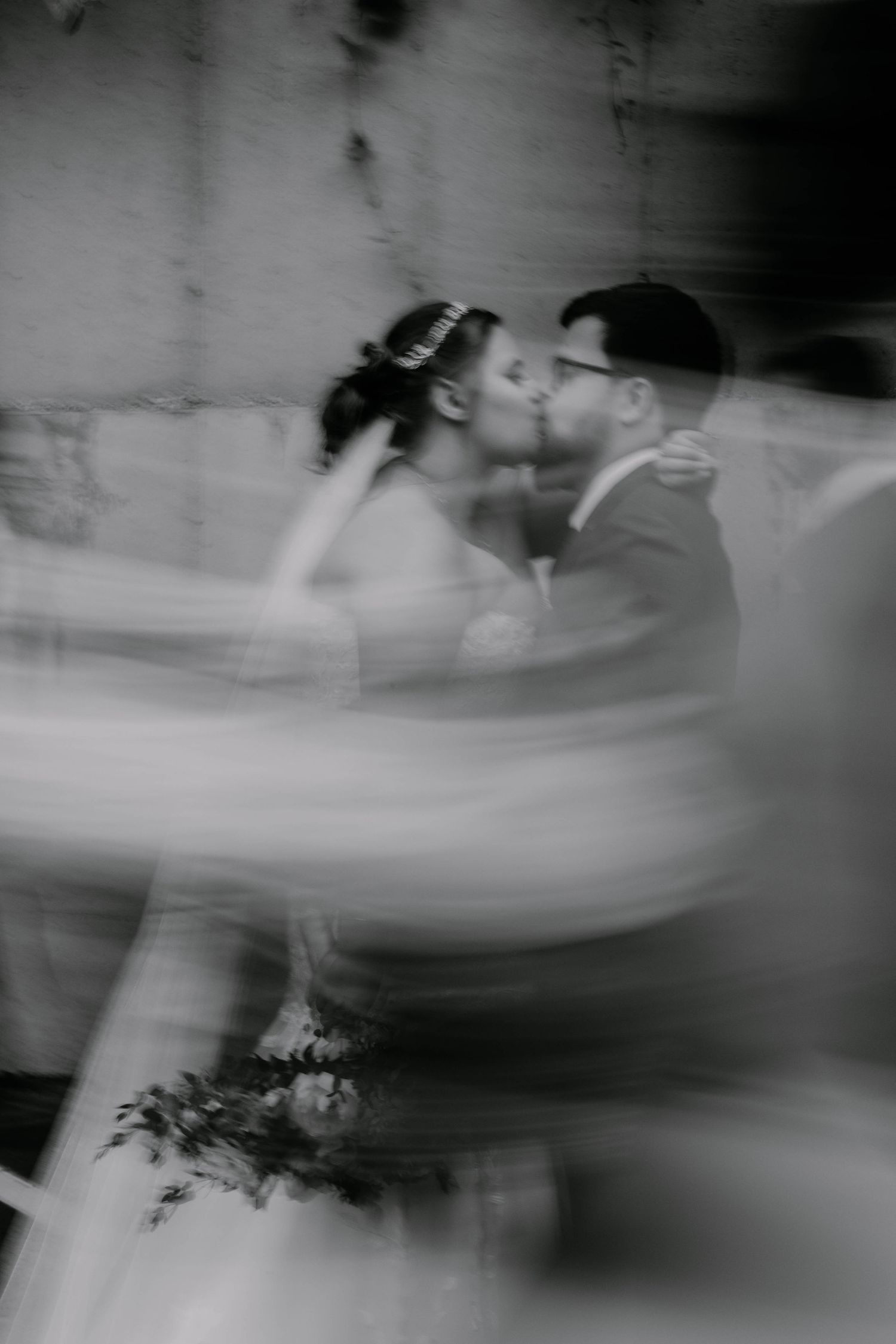 Artistic black and white motion blur photo of wedding couple dancing.