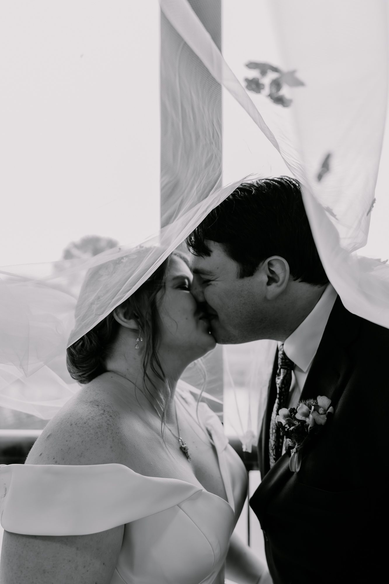 Black and white sequence shows intimate wedding couple kisses during their romantic ceremony moment.