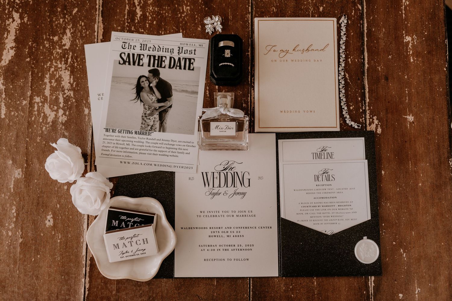 Wedding invitation cards and save the date announcements displayed on a rustic brown wooden background.