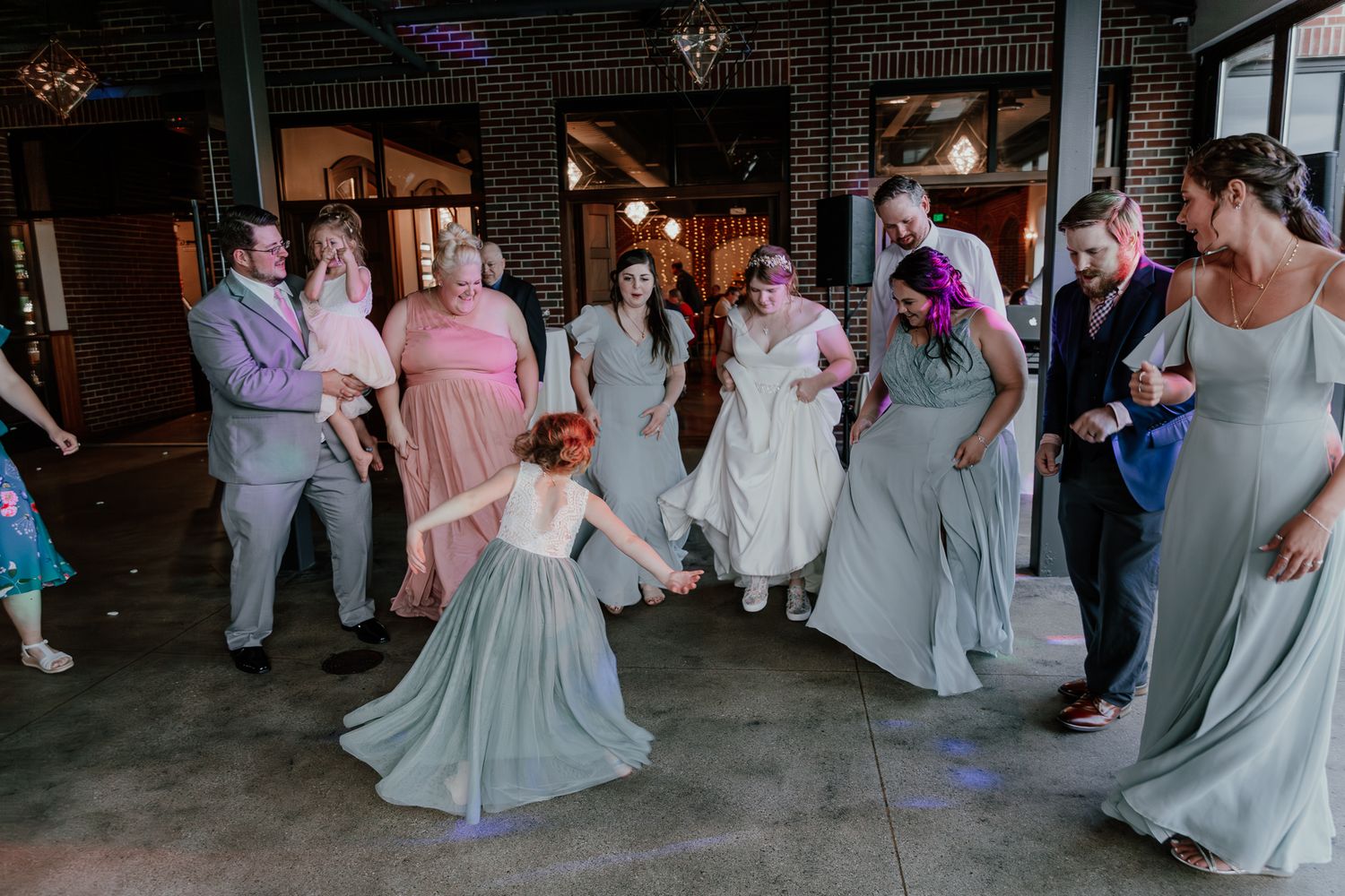 Wedding party dancing and celebrating on the dance floor with joyful expressions.