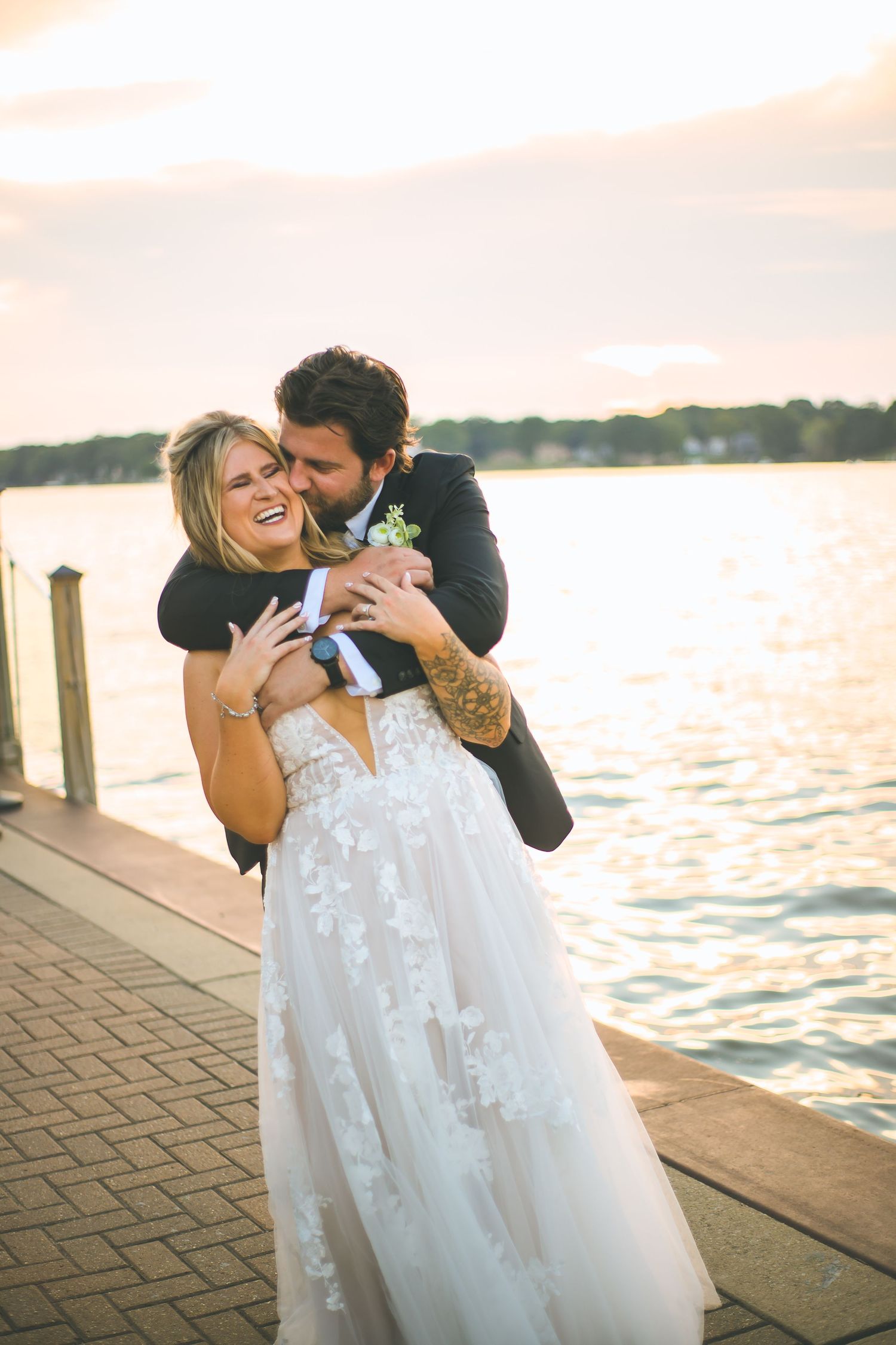 Joyful wedding moments captured on a dock during sunset with water views.