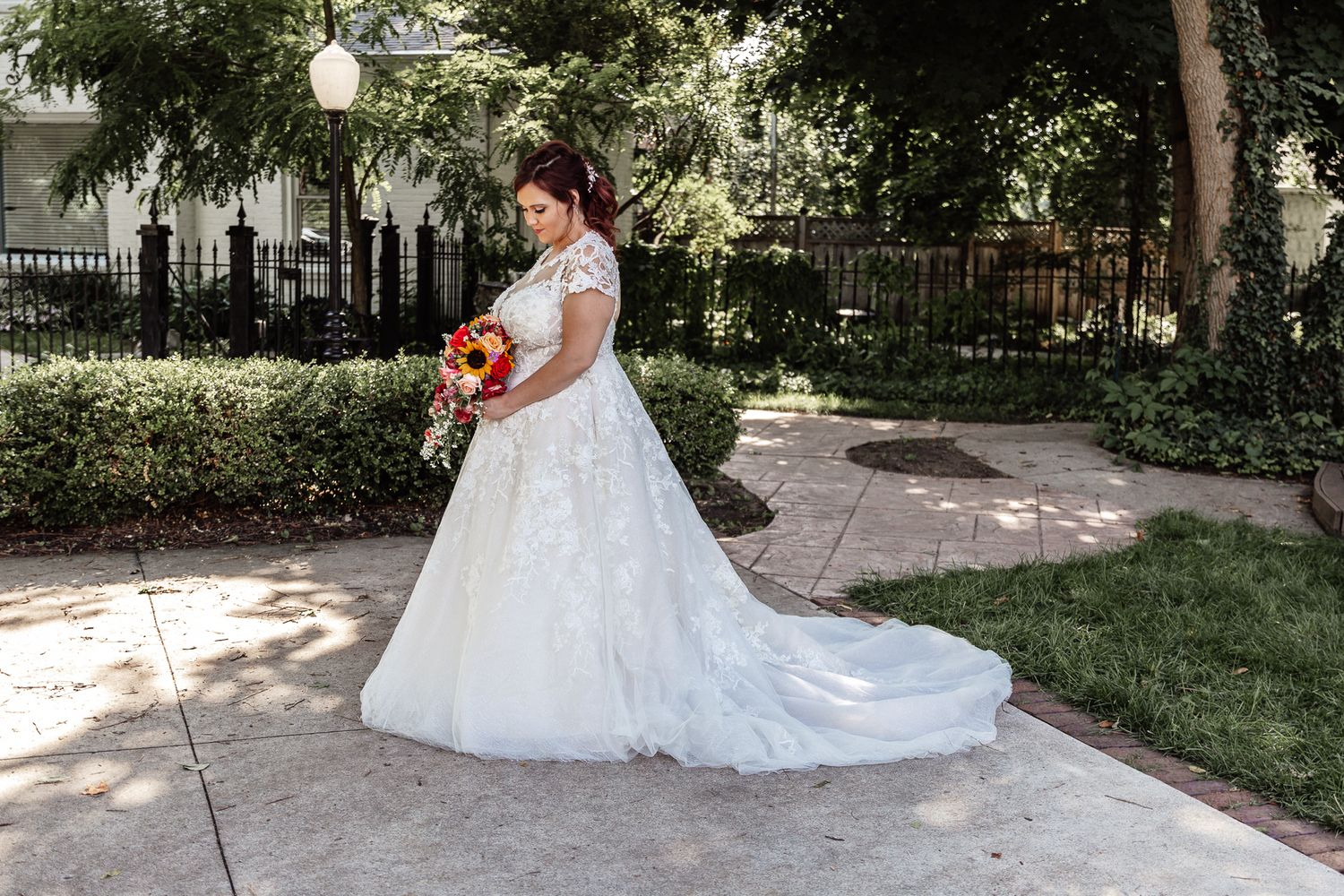 Wedding photography session in a sunlit garden featuring elegant white dress details and natural surroundings.