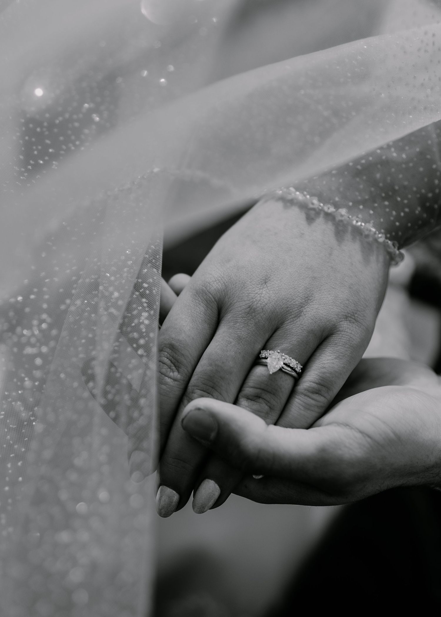 Close-up detail shot of wedding rings exchanged between newlyweds' hands.