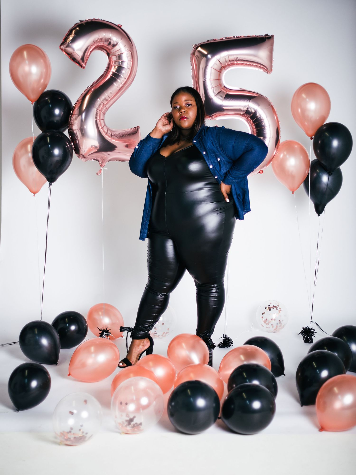 Glamour photoshoot with black and blue styling against balloon decor.