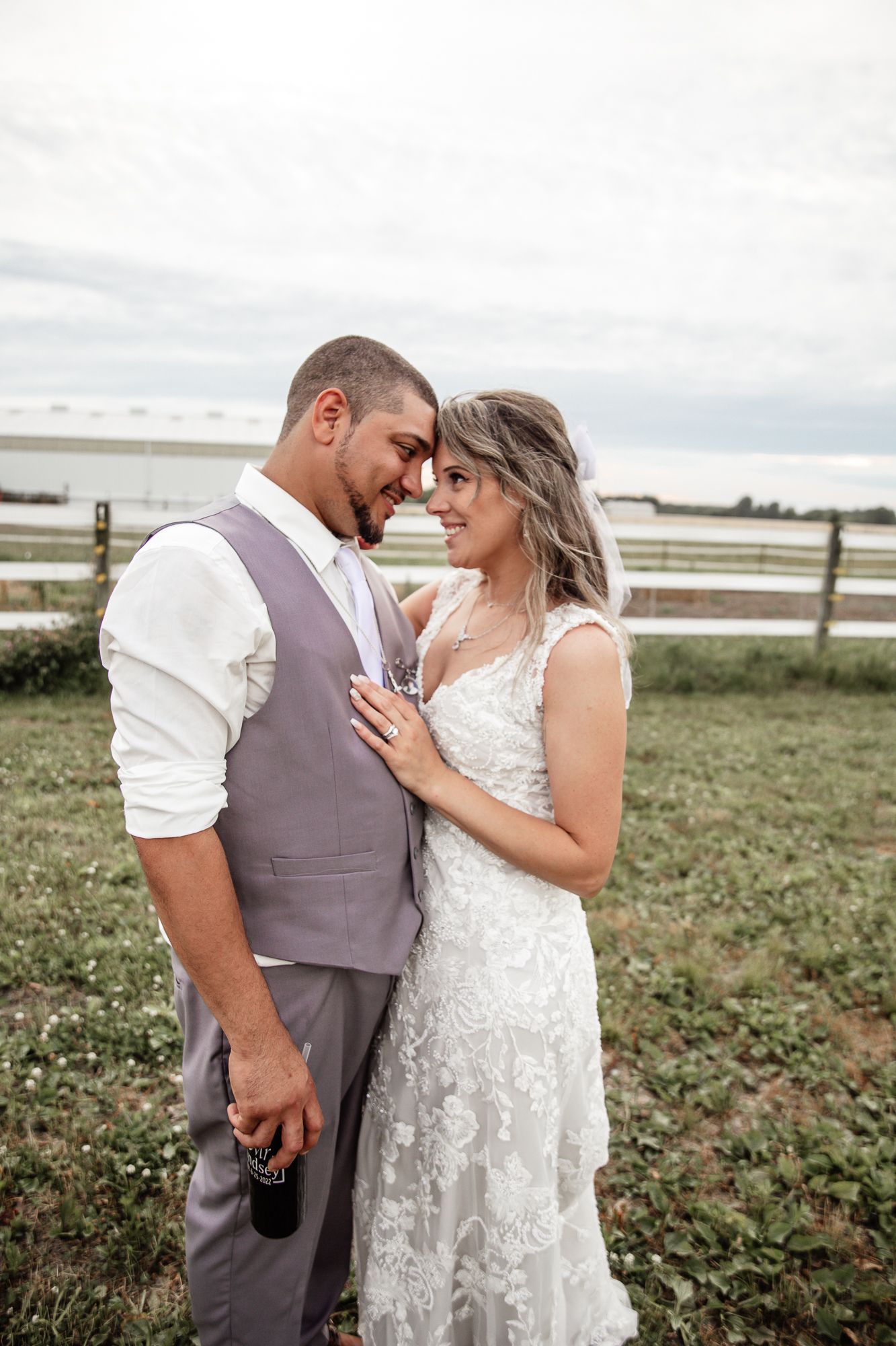 Wedding couple shares intimate moments in a rustic farm setting.