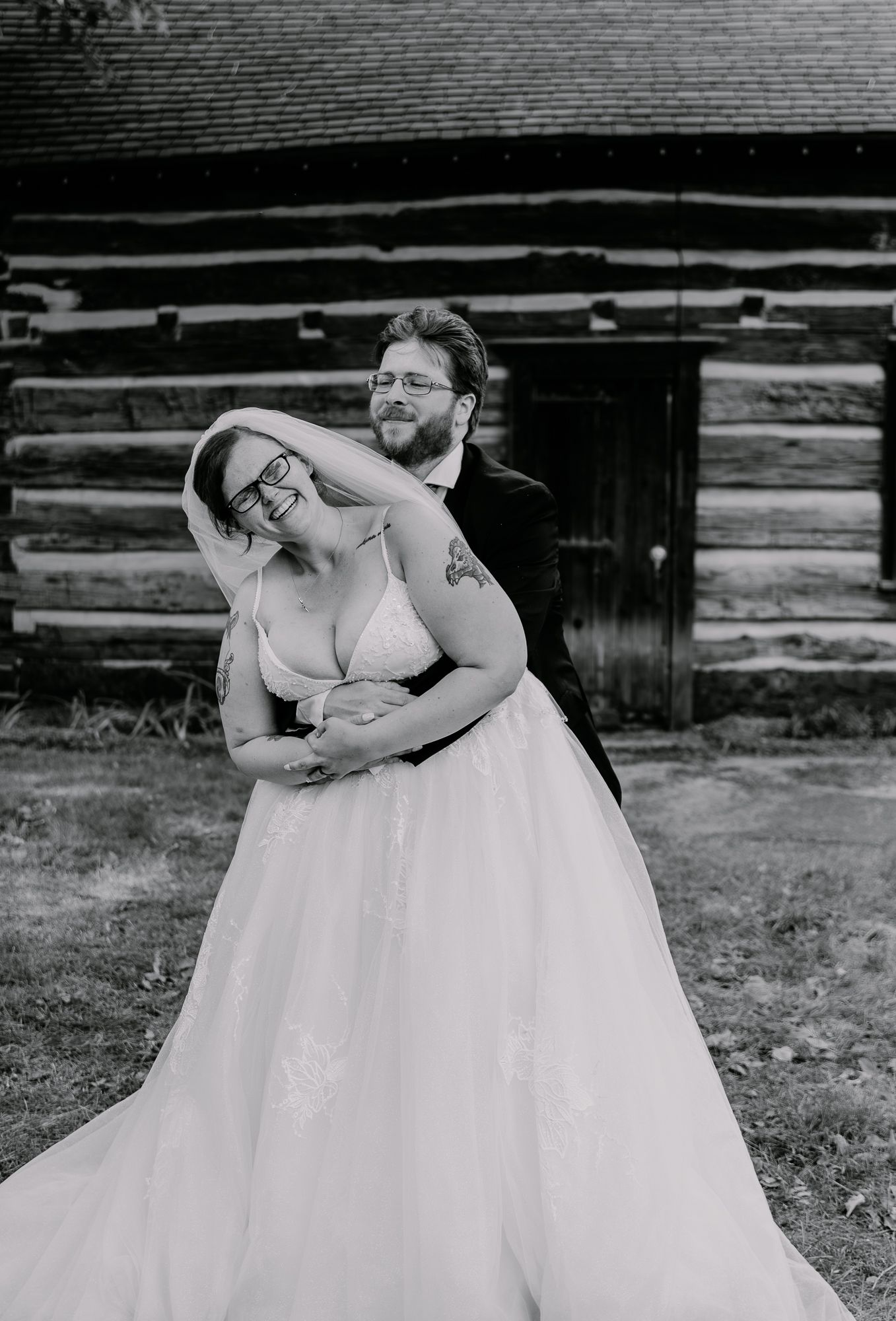 Black and white photo of couple embracing in formal wedding attire.