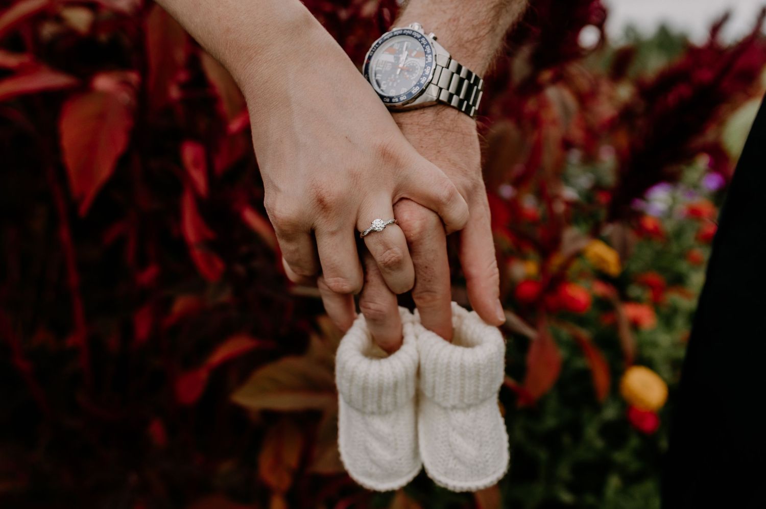 Seven sequential photos showing hands holding white baby shoes with seasonal red florals and decorations in the background.