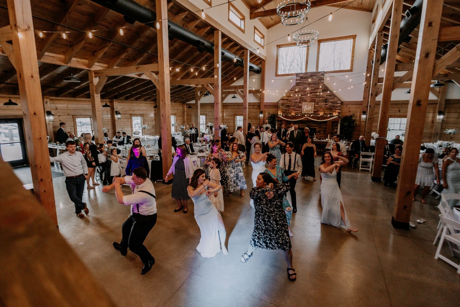 Guests enjoying dancing at a rustic barn wedding reception.