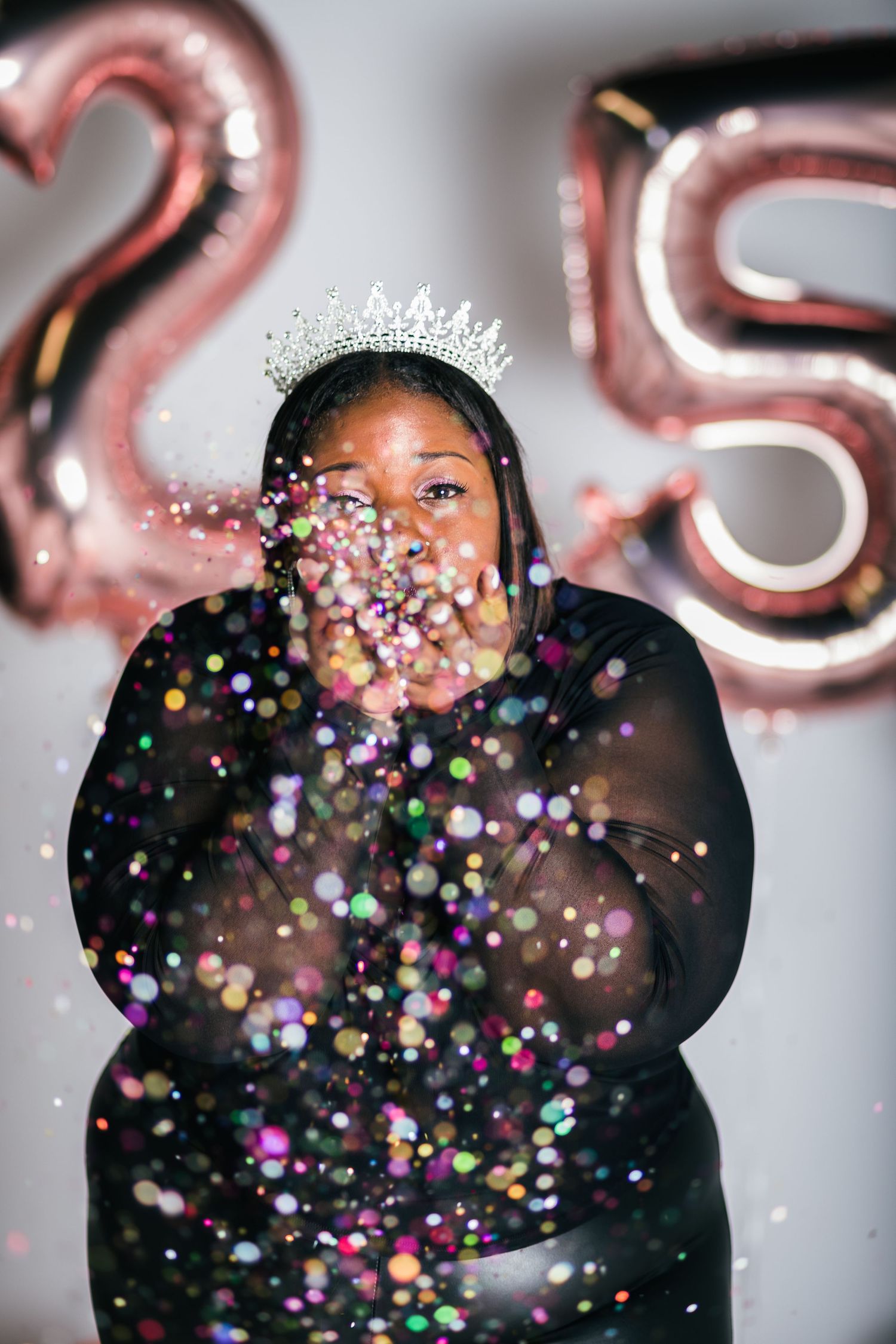 Celebratory moment with colorful confetti against balloon backdrop.