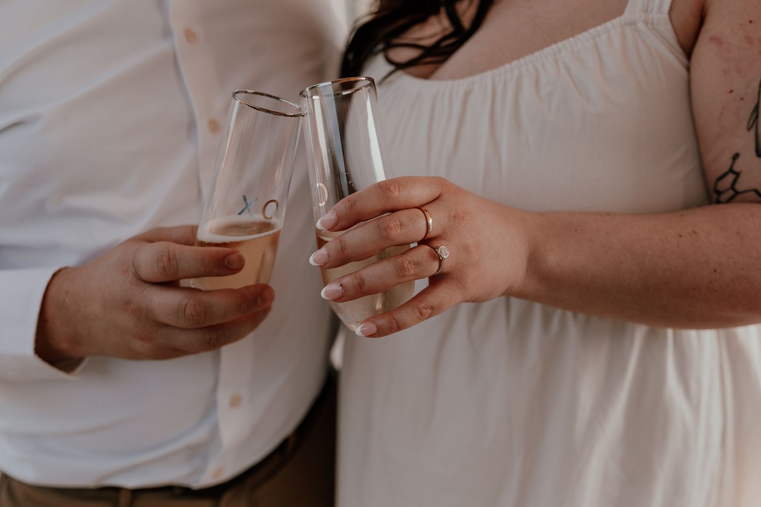 Close-up of champagne glasses being held during a celebration moment.