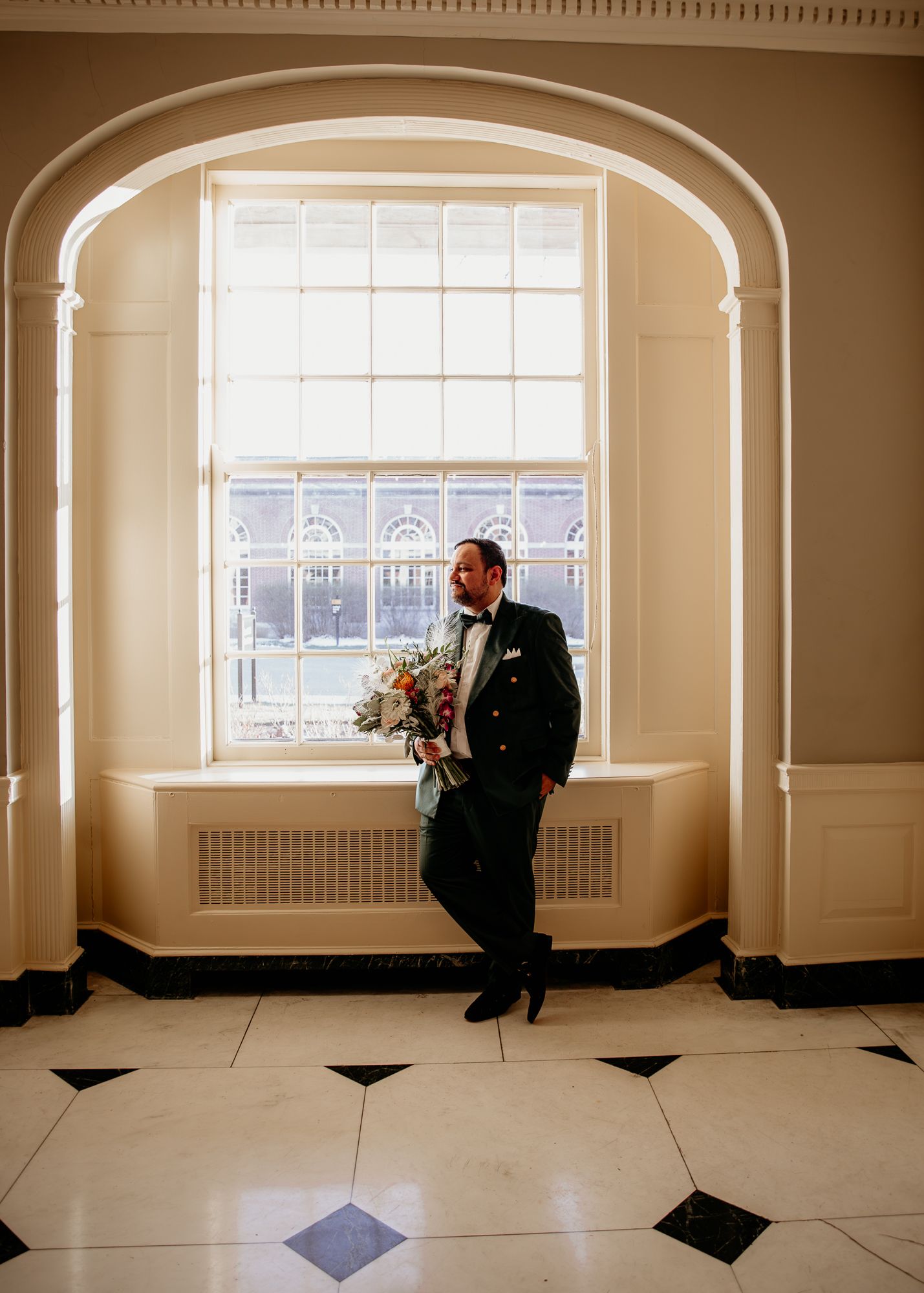 Light filled room with elegant checkered floor and arched windows creates dramatic shadows.