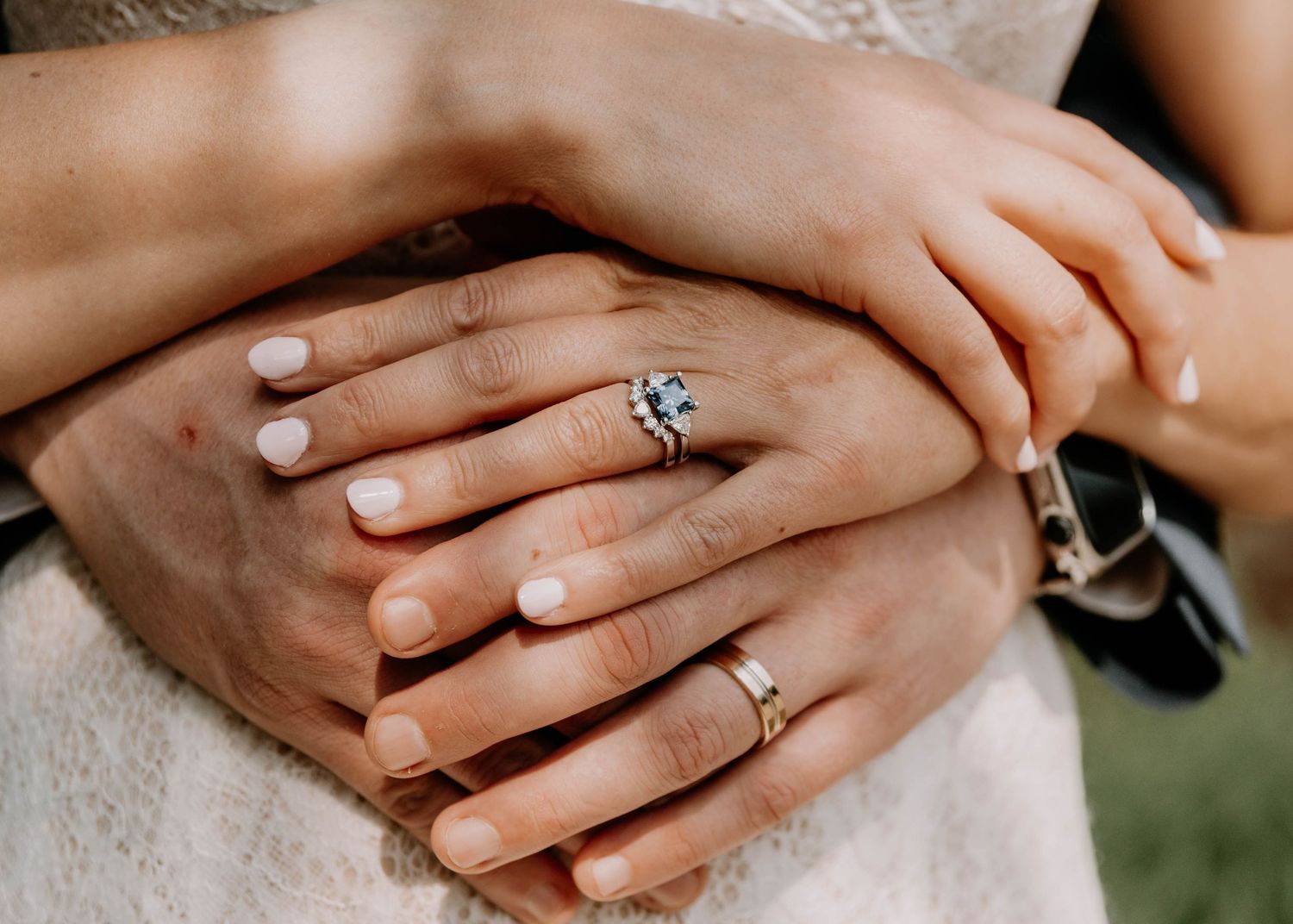 Close-up of bride and groom's hands showing wedding rings and engagement ring.