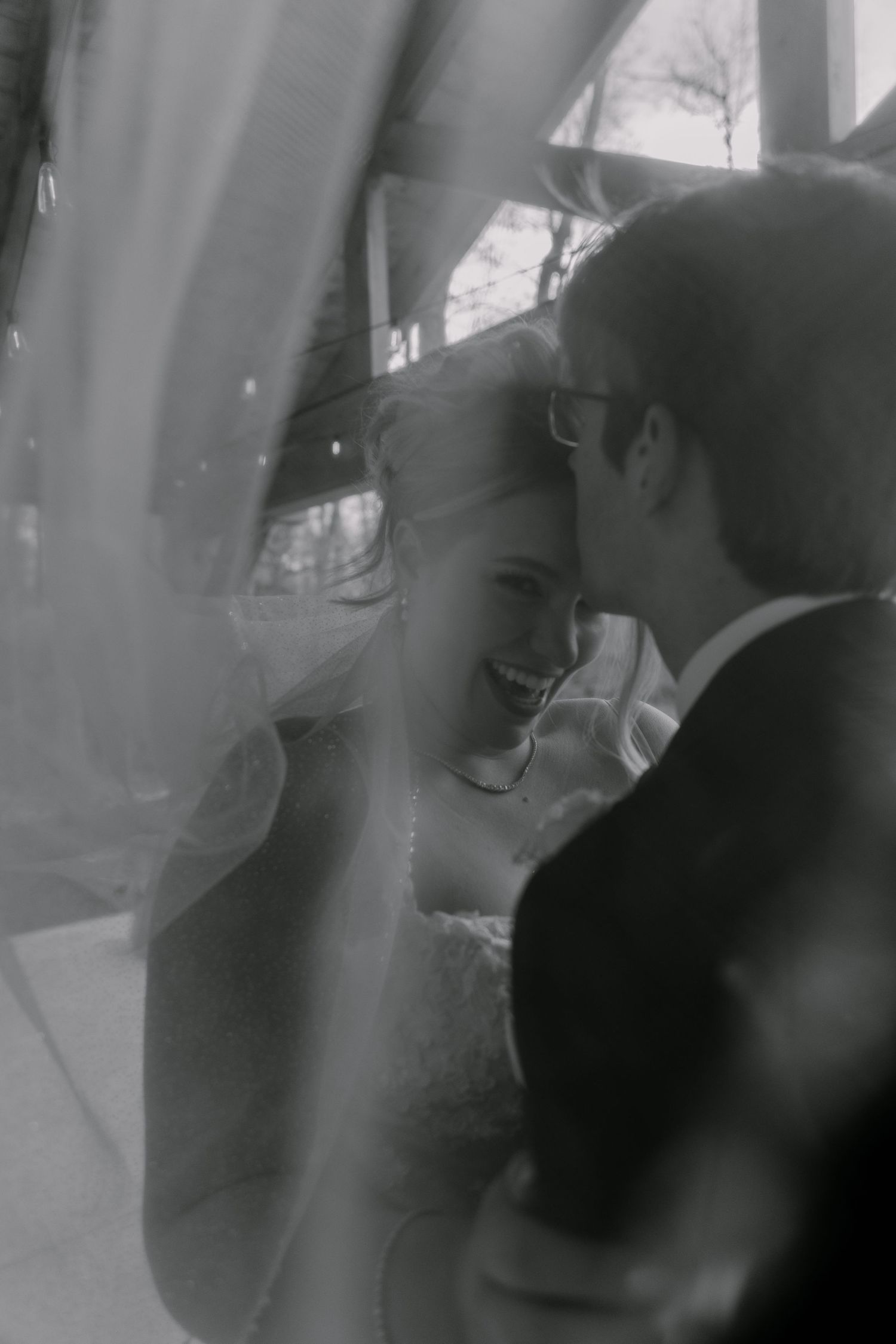 Artistic black and white portrait of newlyweds sharing intimate moment.