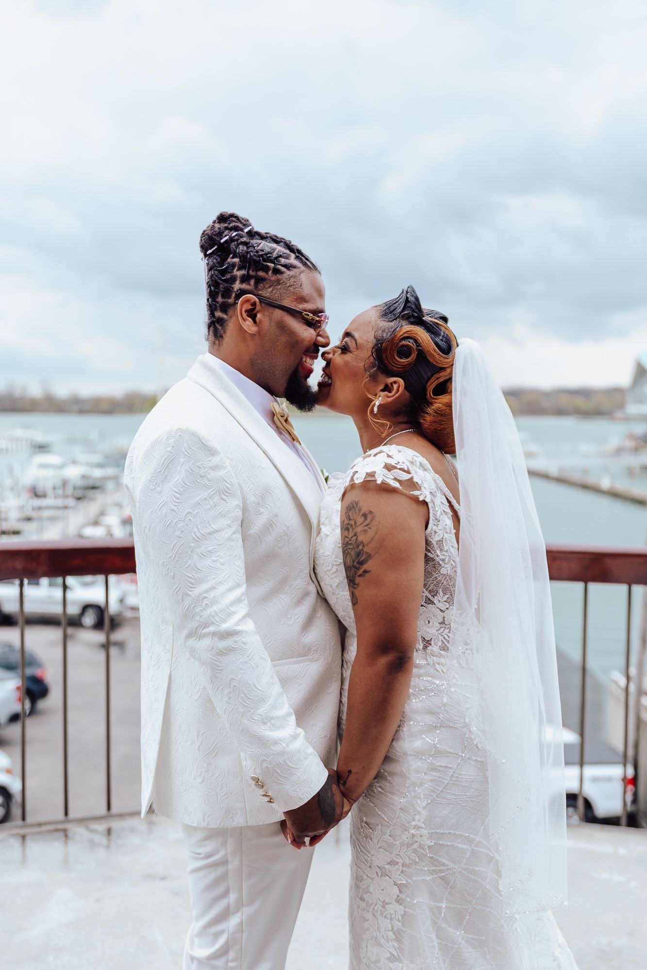 Close-up of newlyweds sharing romantic moment on marina balcony.