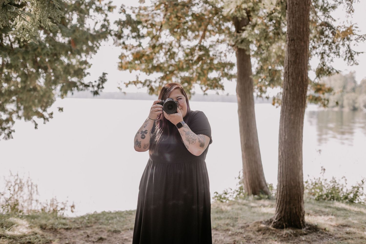 A couple shares a loving embrace during an outdoor photoshoot amongst tall trees in a misty wooded setting.