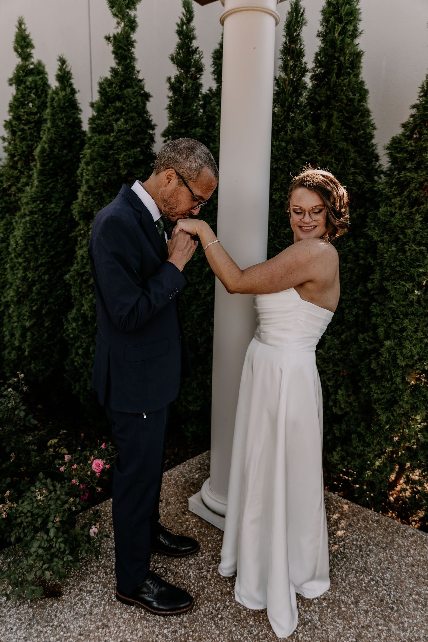 A romantic wedding moment captured in a sequence of four photos showing a couple embracing against a backdrop of cypress trees.