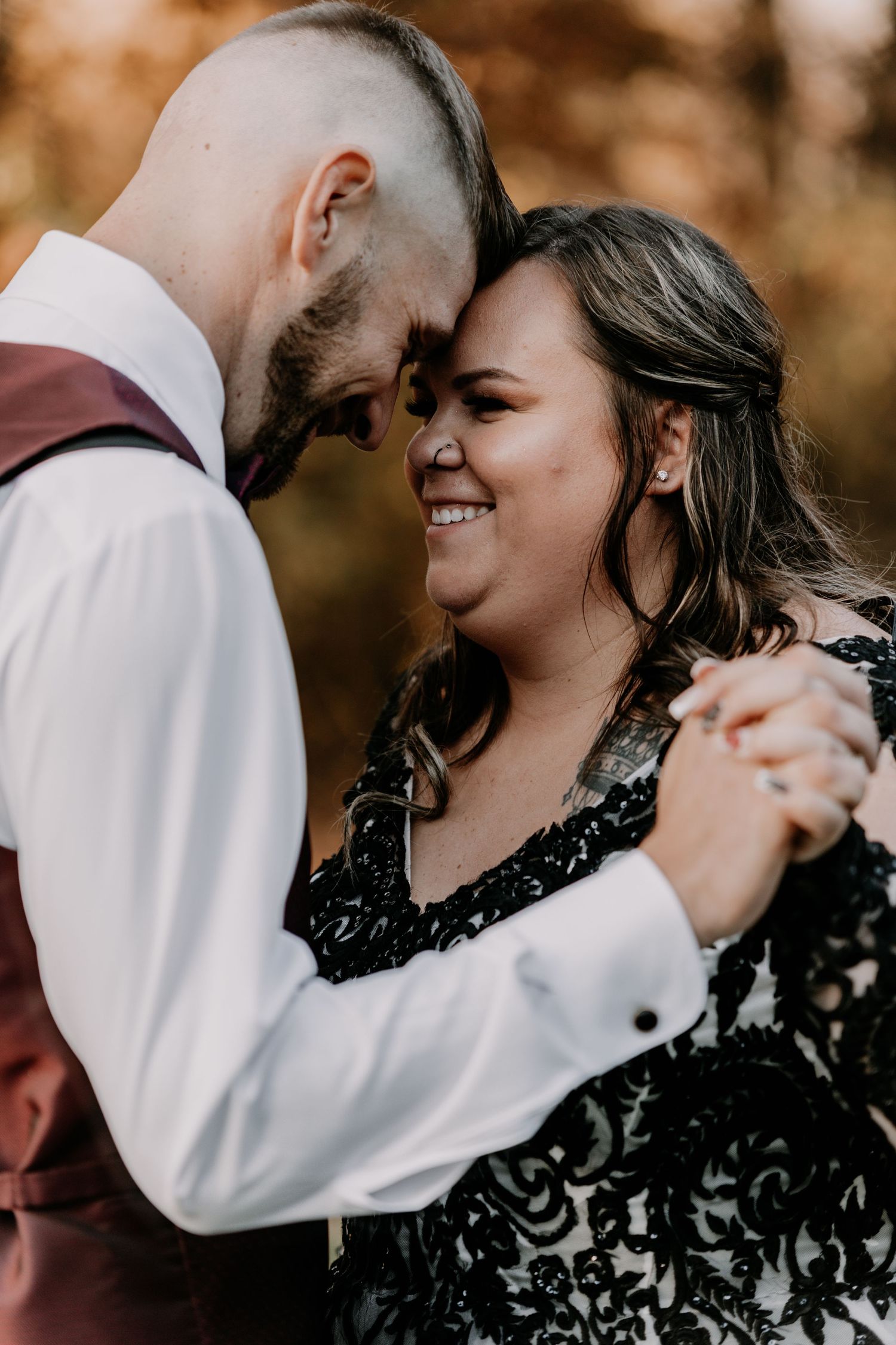 A romantic intimate moment between bride and groom dancing together at an autumn wedding.