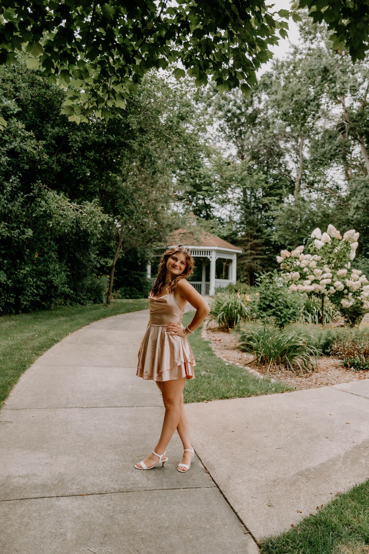 A summer photoshoot on a paved walkway surrounded by garden landscaping.