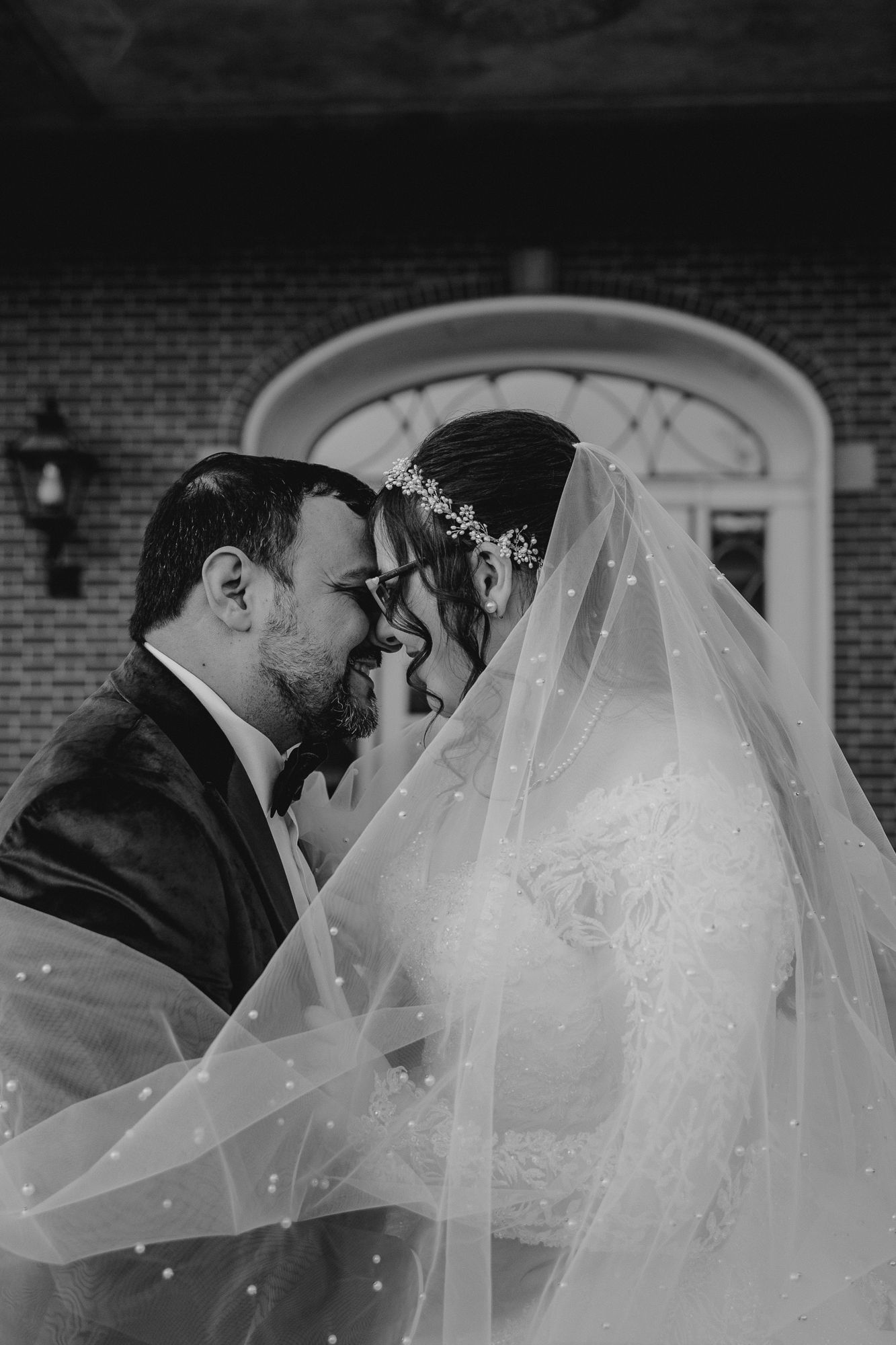 Intimate black and white wedding portraits with dramatic veil detail.