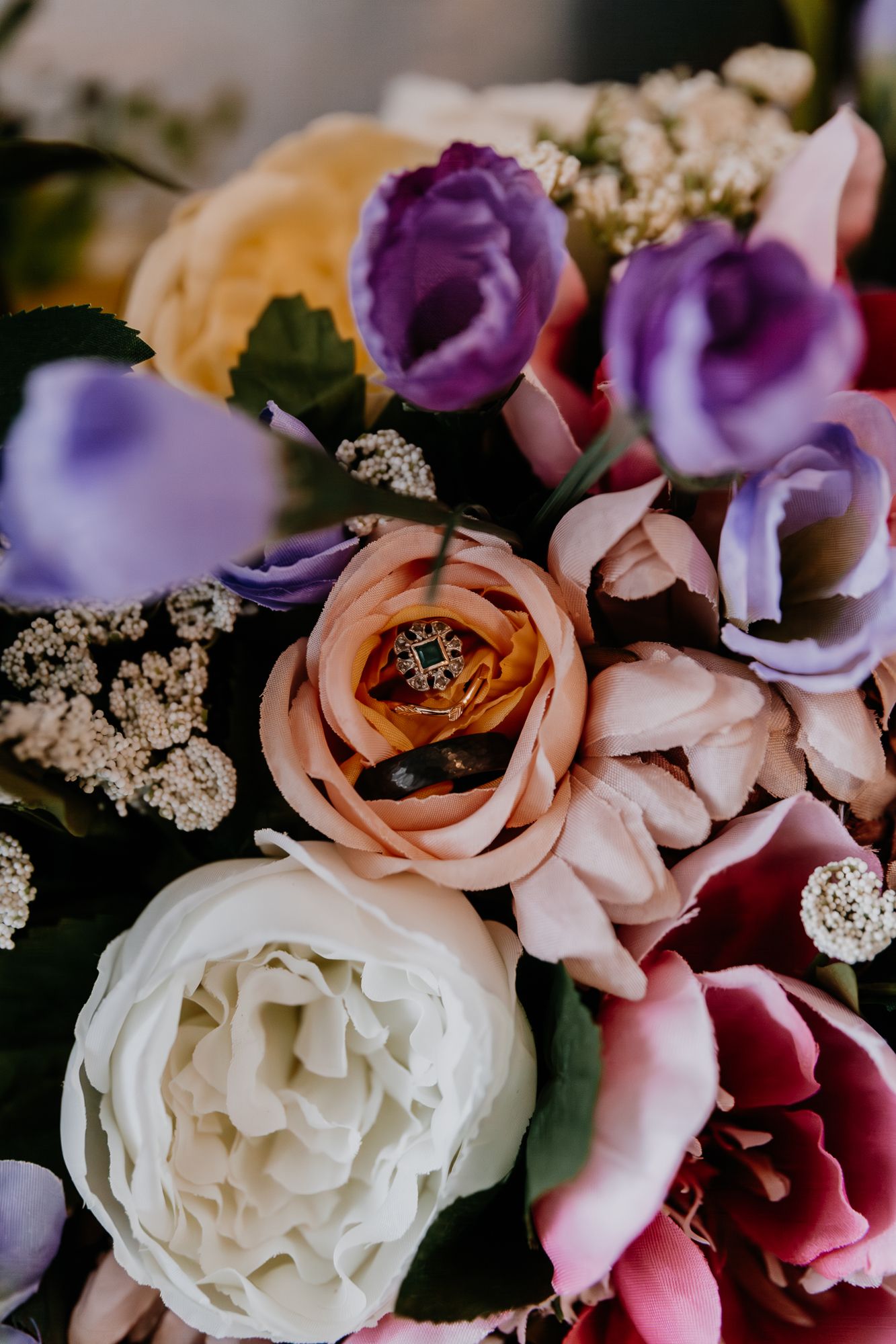 Close-up of elegant wedding bouquet with purple, pink and white roses.