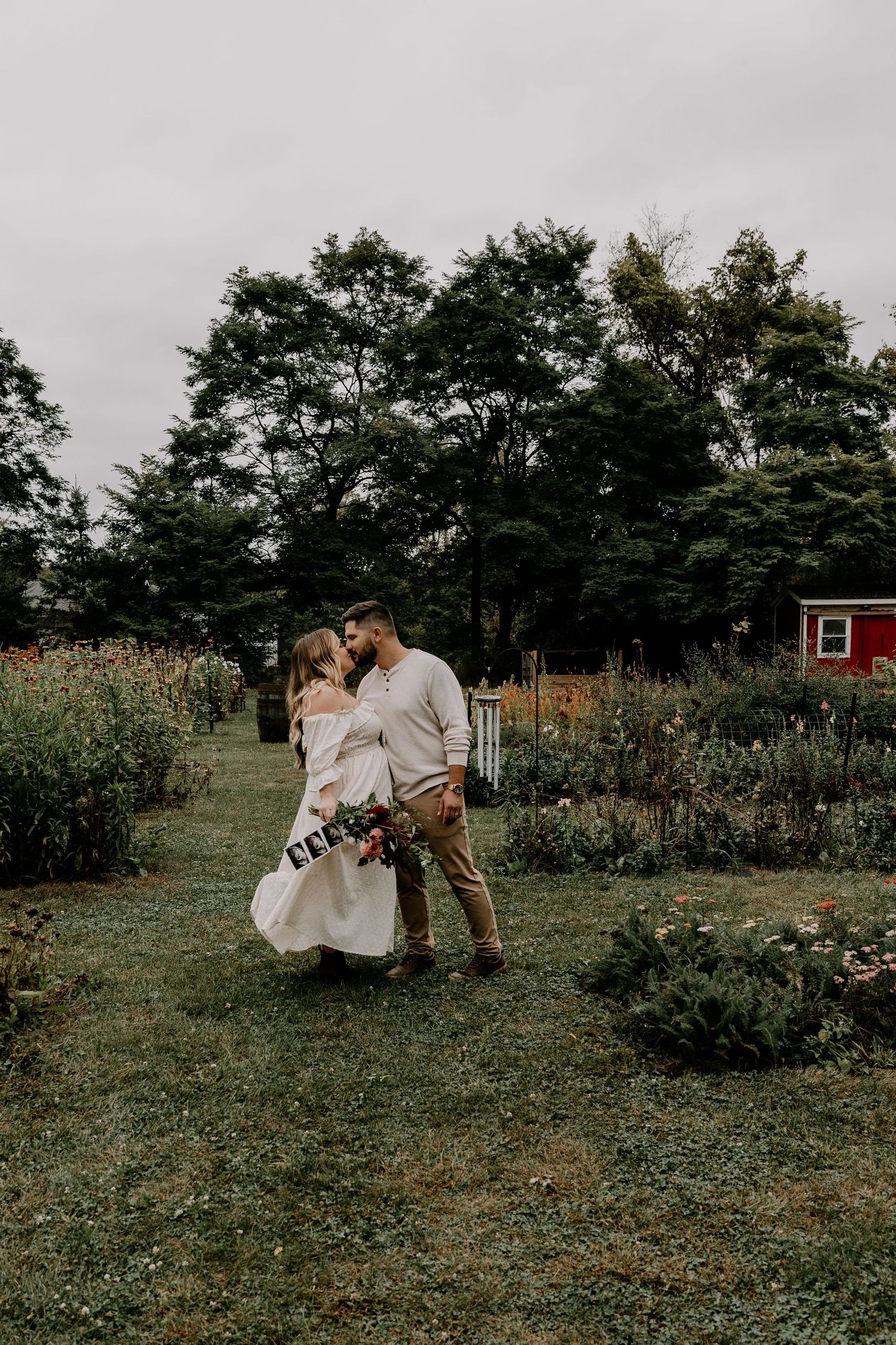 A romantic outdoor photoshoot in a garden setting with blooming flowers and greenery.
