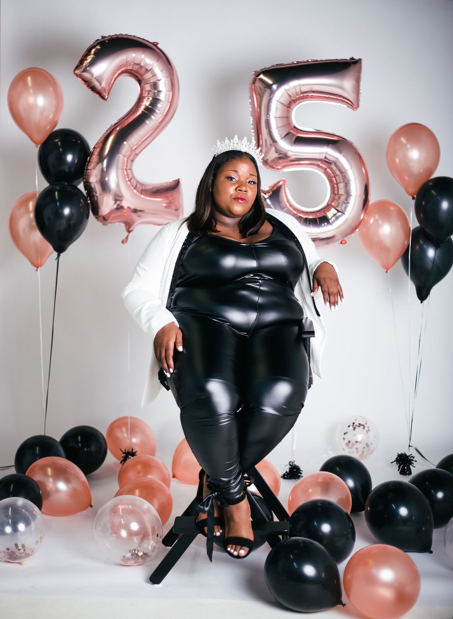 Stylish leather ensemble photographed with pink and black balloon arrangement.