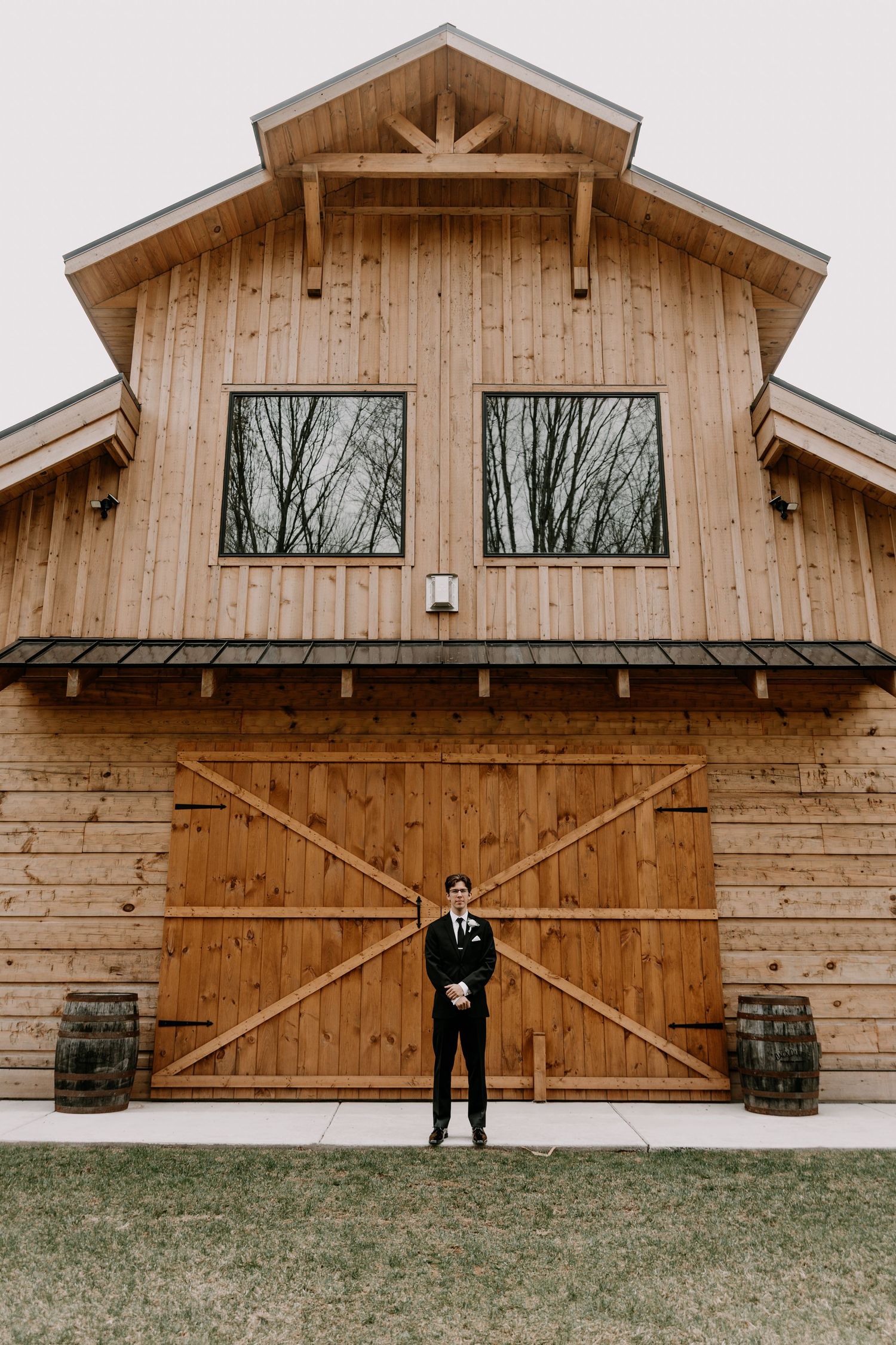 Wedding venue barn exterior showing rustic wooden architecture and barrels.