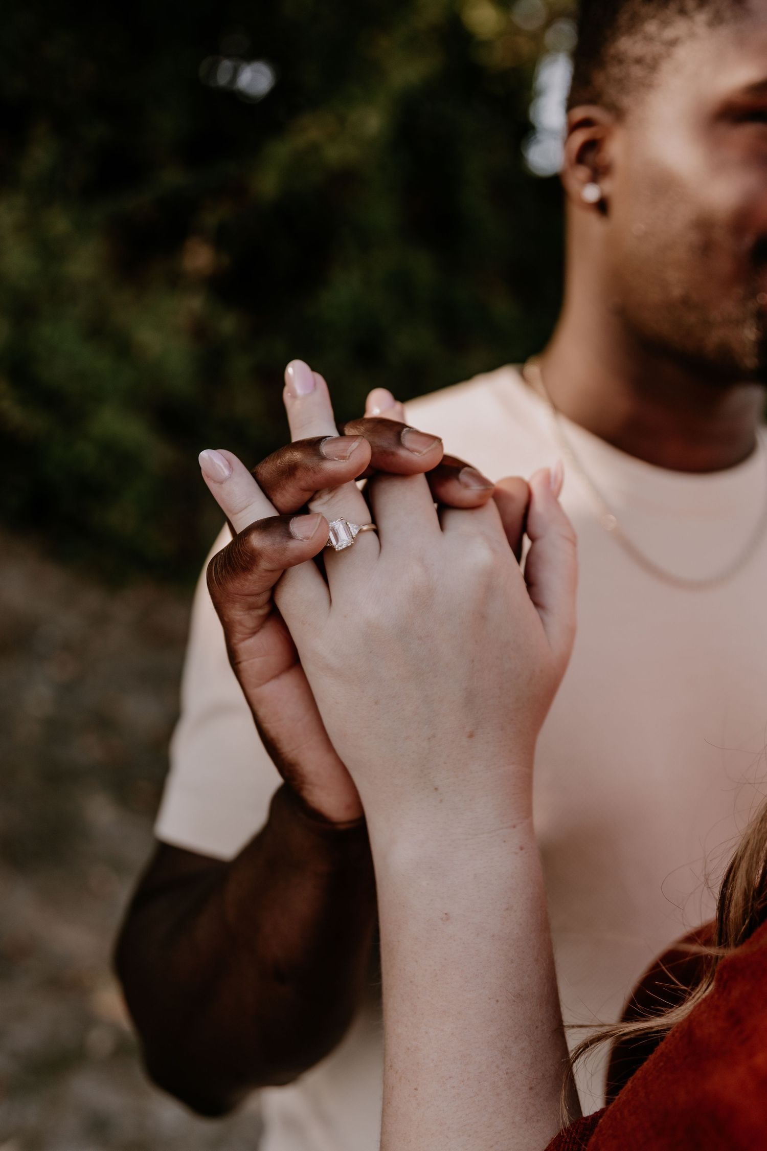 Close-up sequence of two hands coming together and intertwining fingers in romantic engagement pose.