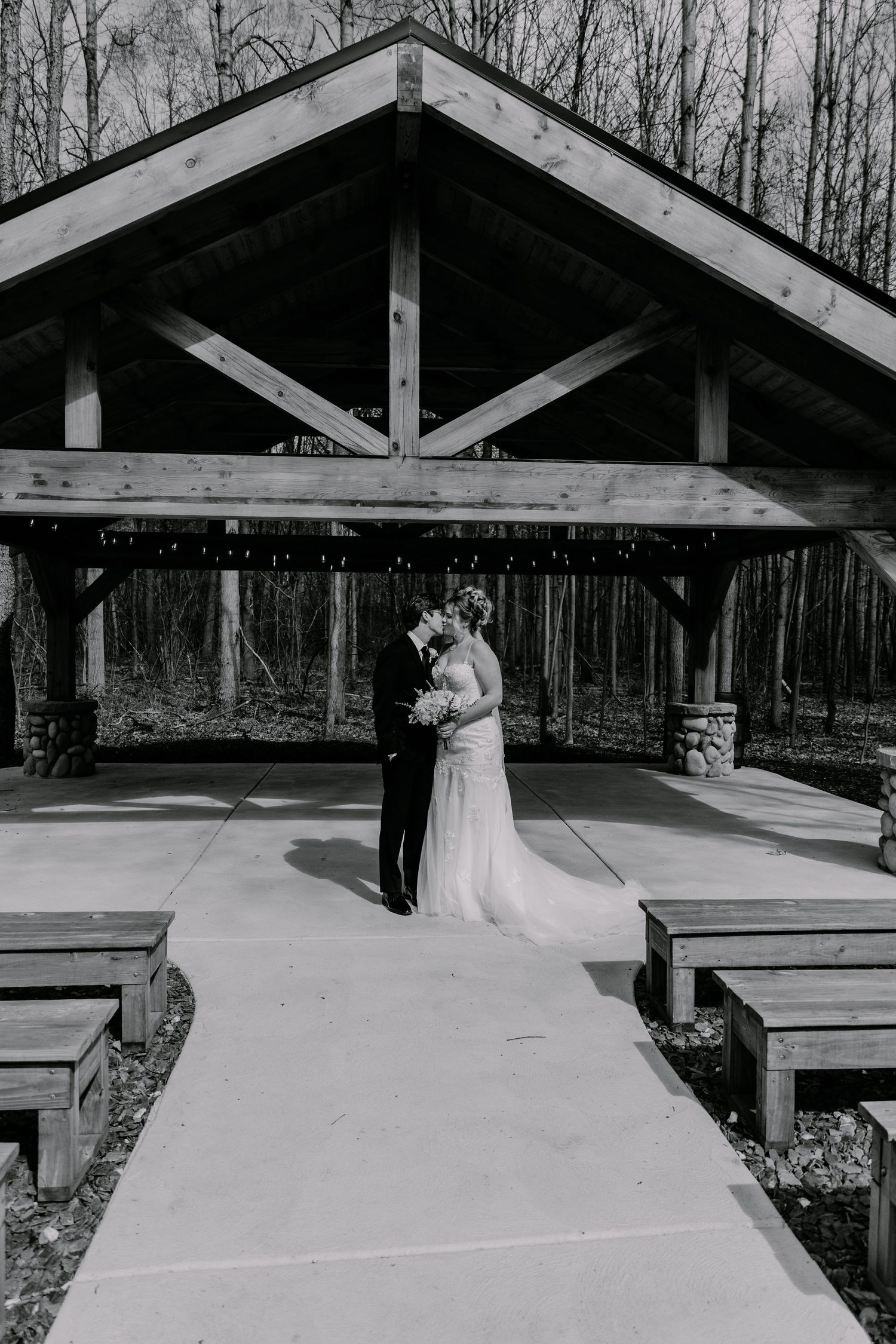 Black and white panoramic of a covered outdoor wedding ceremony space.
