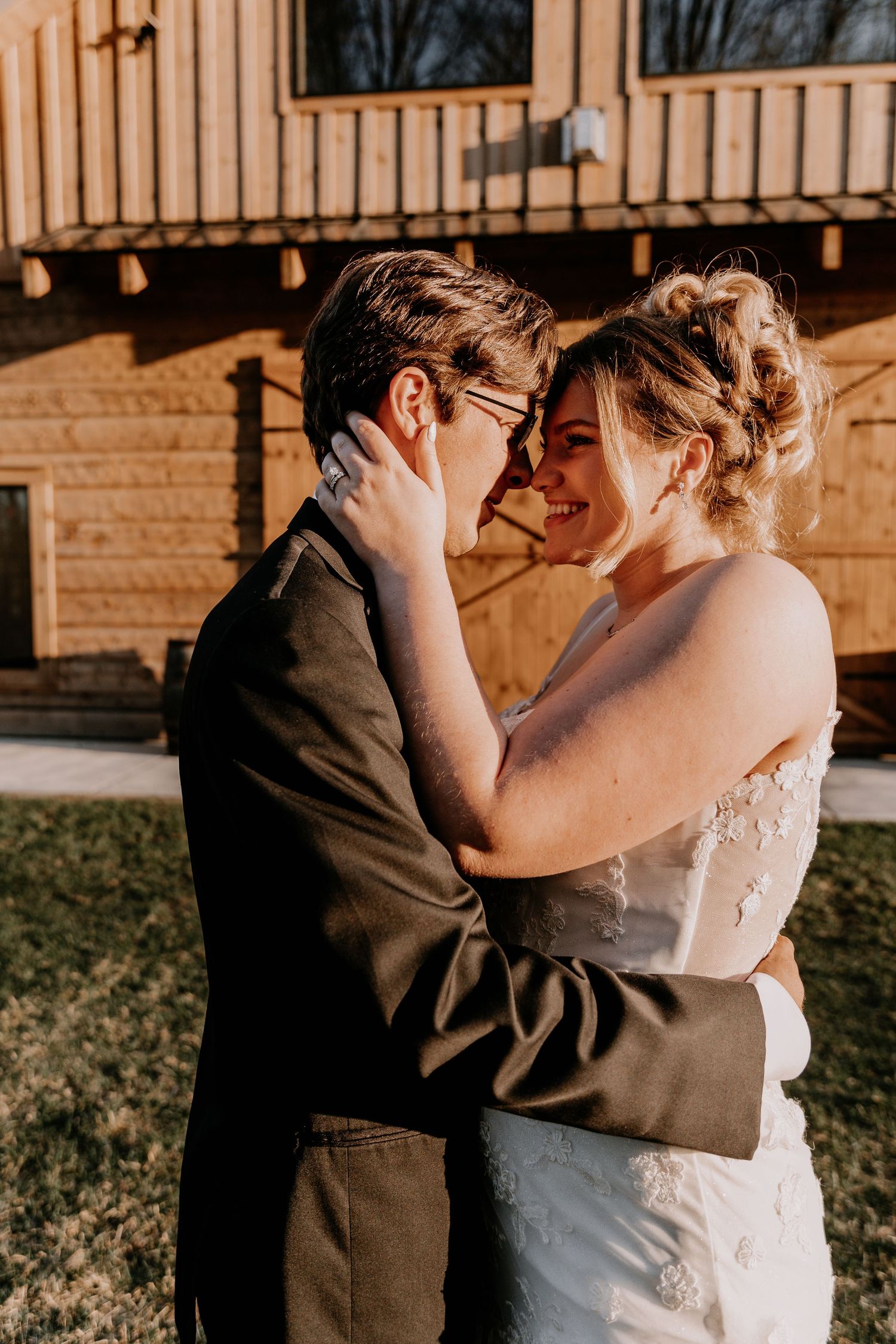 A tender moment between newlyweds sharing an intimate embrace in golden sunlight.