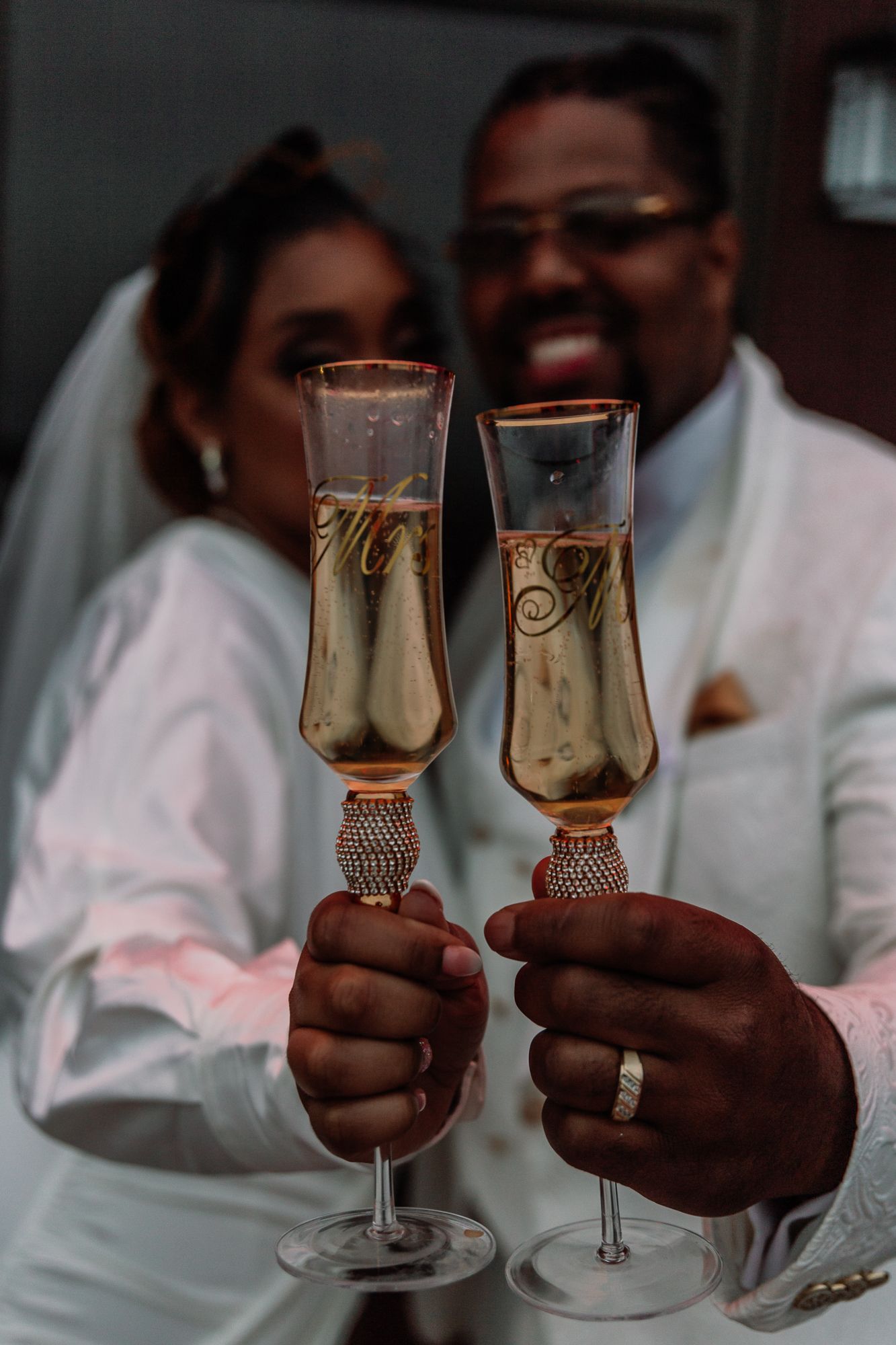 Wedding couple toasts with elegant champagne flutes decorated with crystals.