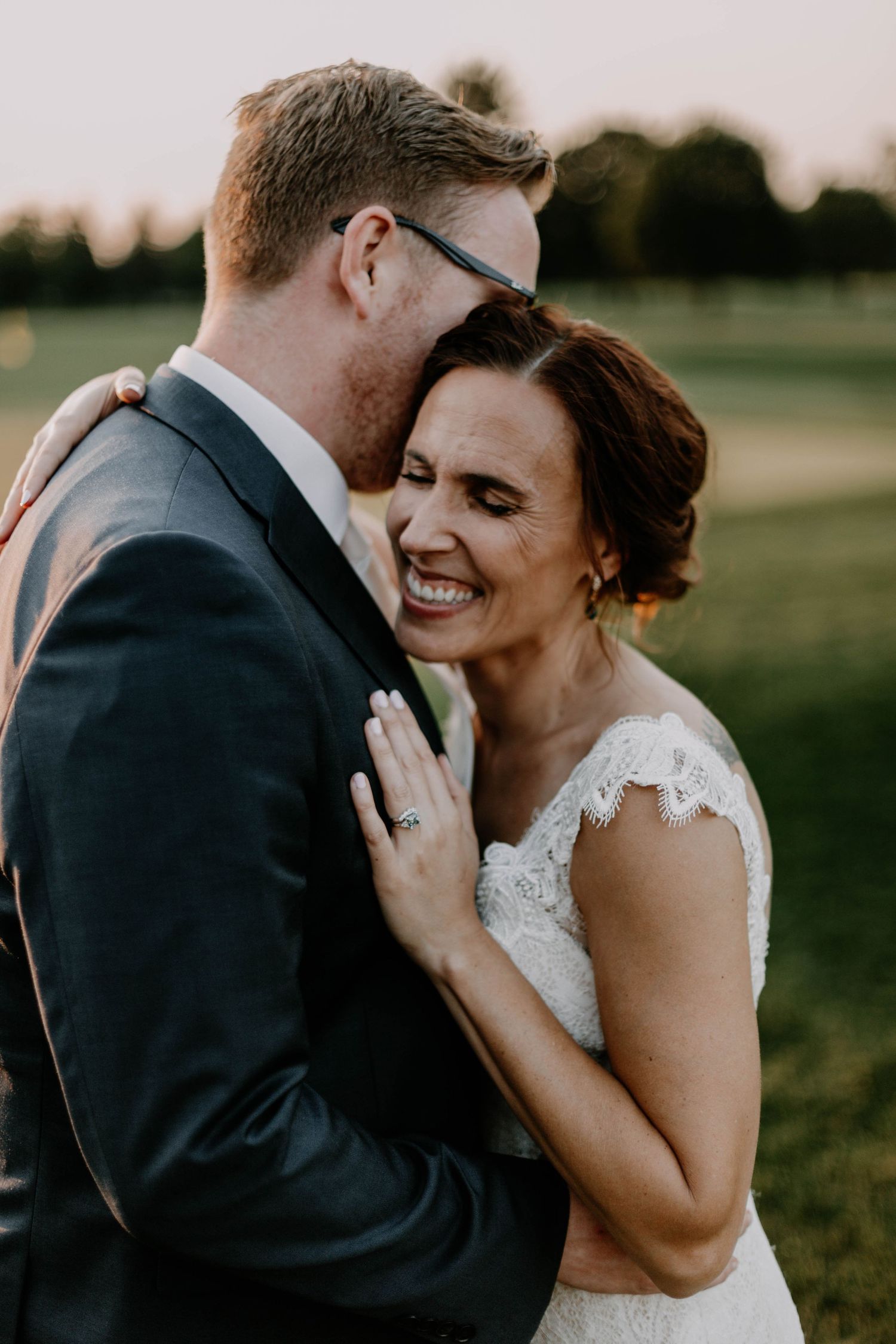 An intimate moment between newlyweds sharing laughter during their sunset portrait session.