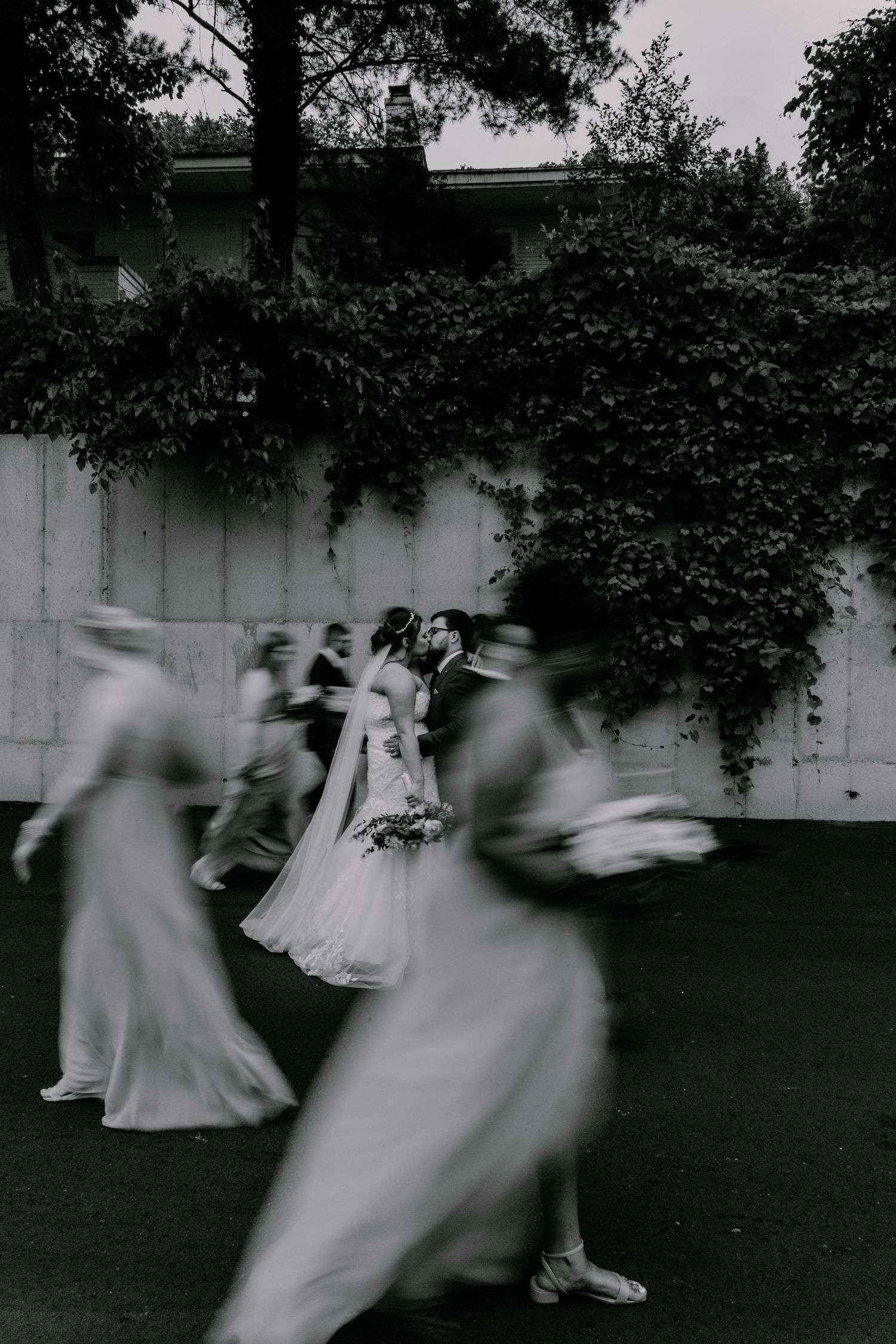 Motion-blurred artistic shot of wedding party dancing outdoors.