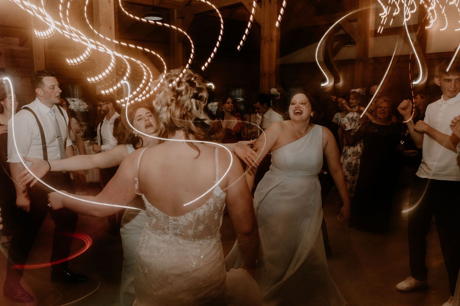 Wedding reception dance party with string lights creating a warm ambiance.