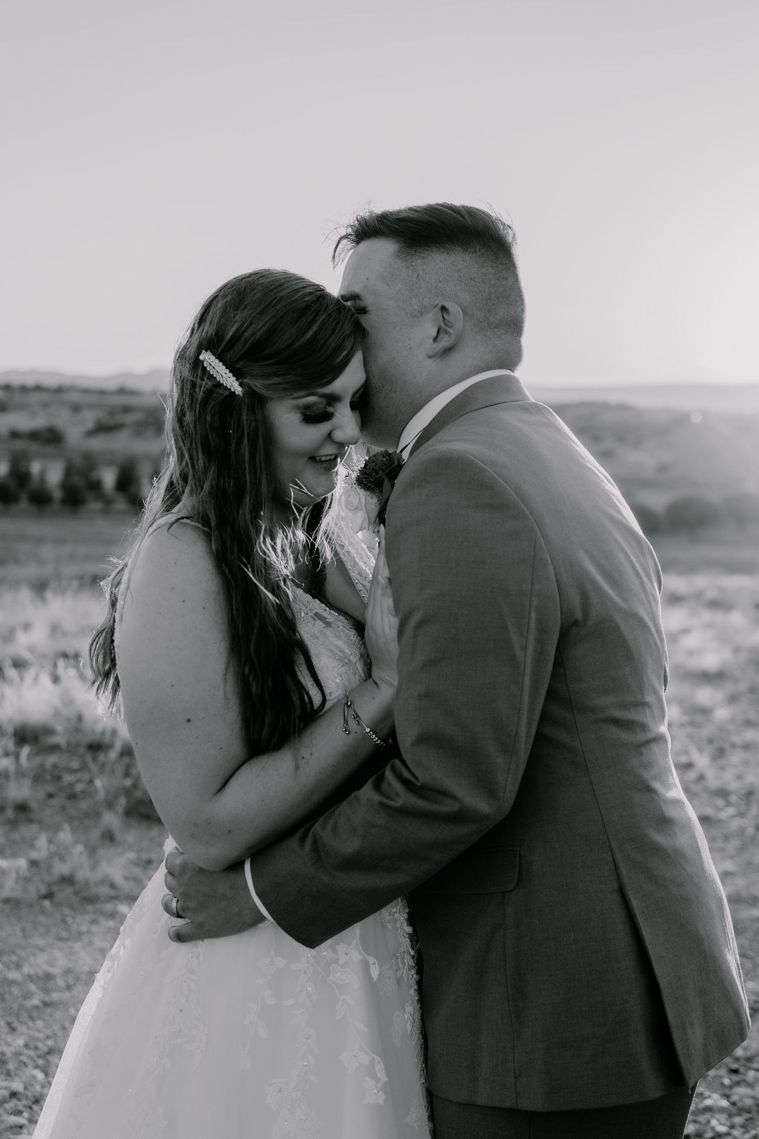 Black and white intimate portrait of newlyweds sharing a tender moment.