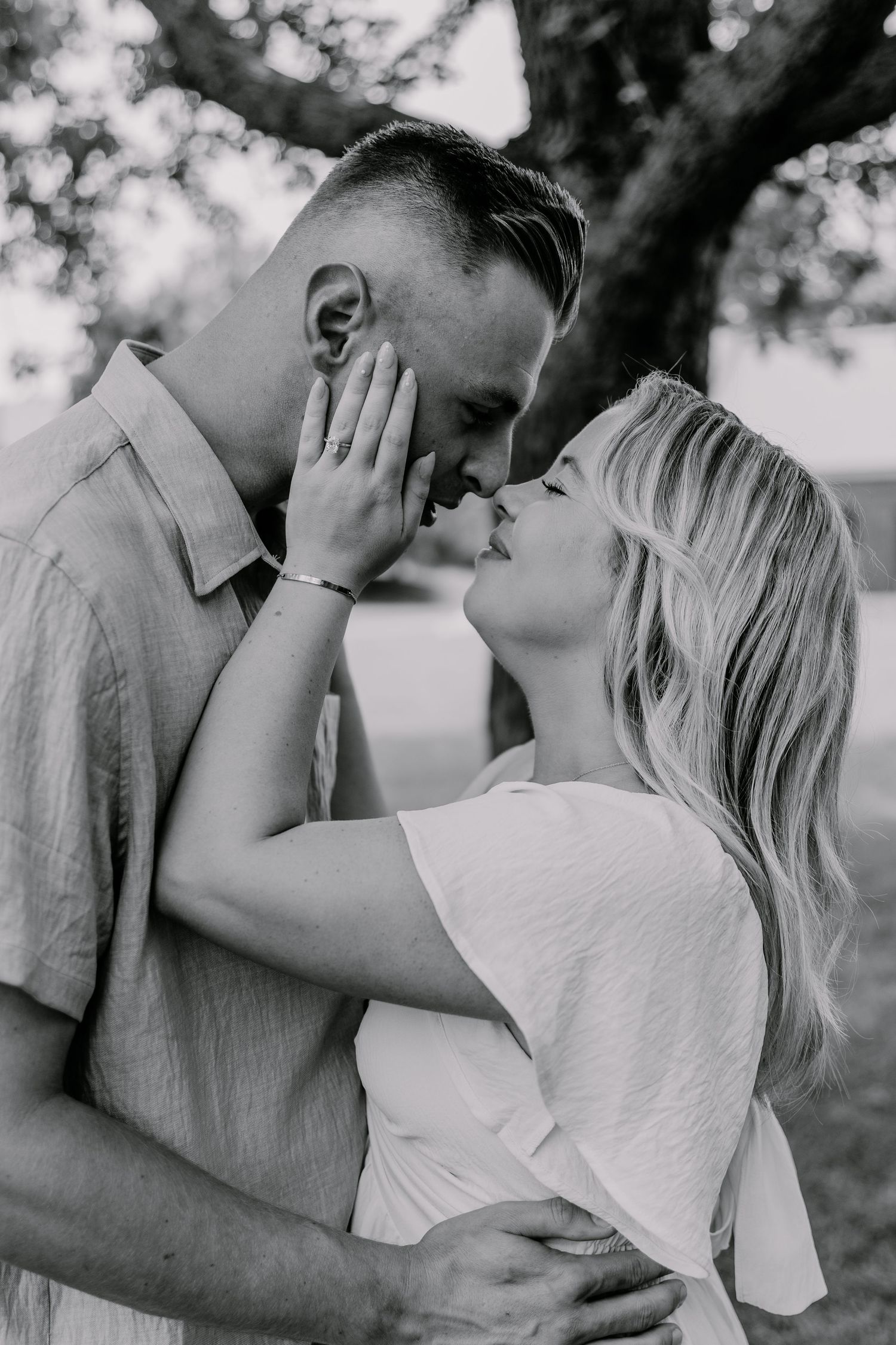A romantic black and white photo sequence showing a couple embracing and sharing tender moments outdoors.
