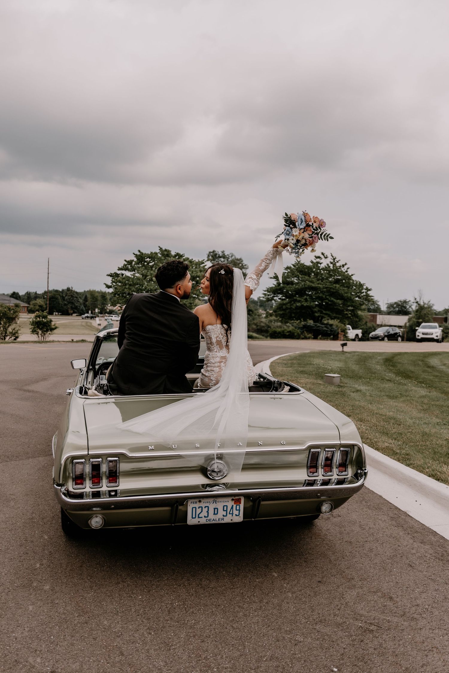 A vintage white Ford Mustang convertible photographed from different rear angles at an outdoor venue.