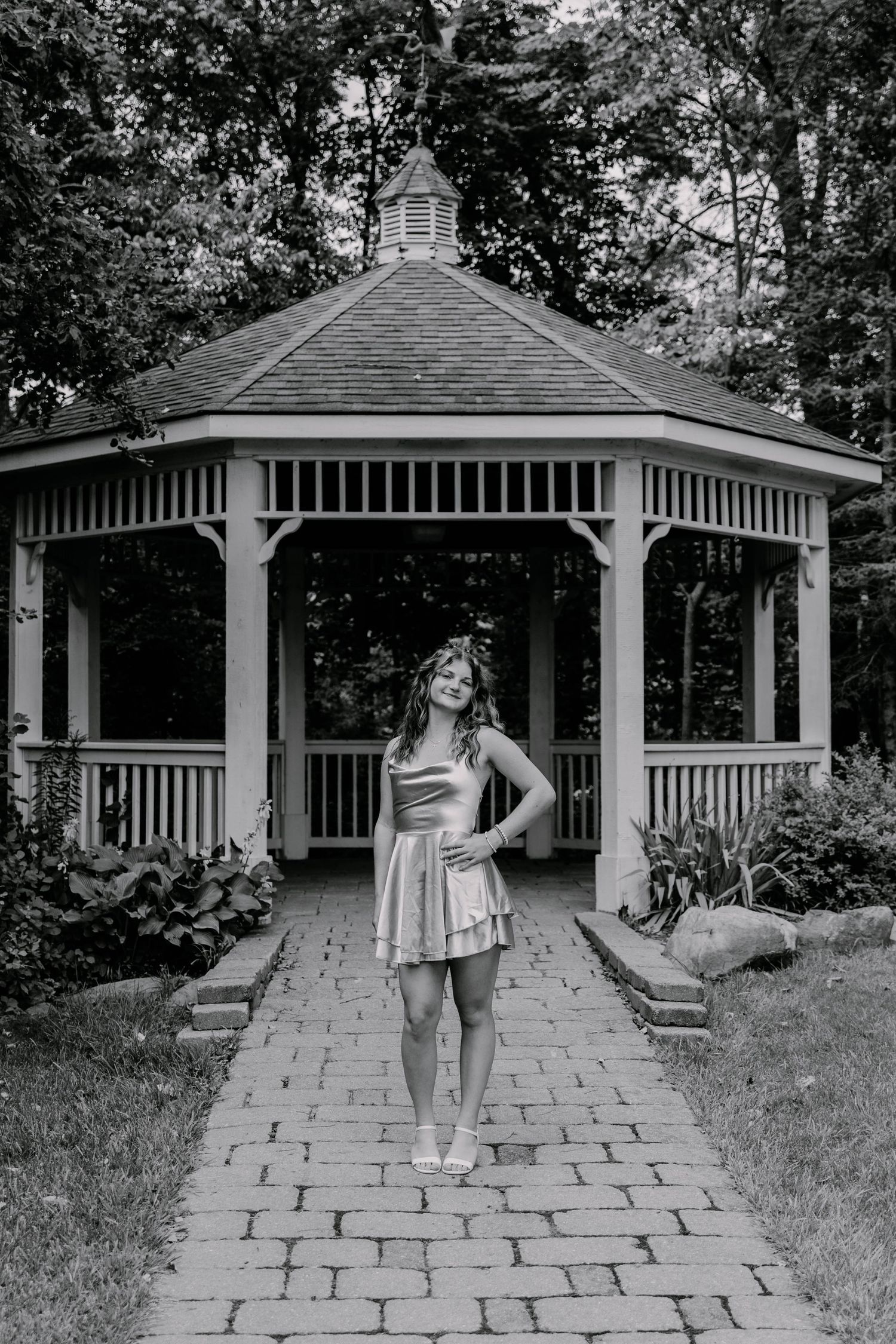 A series of poses captured in front of a white gazebo surrounded by landscaped gardens.