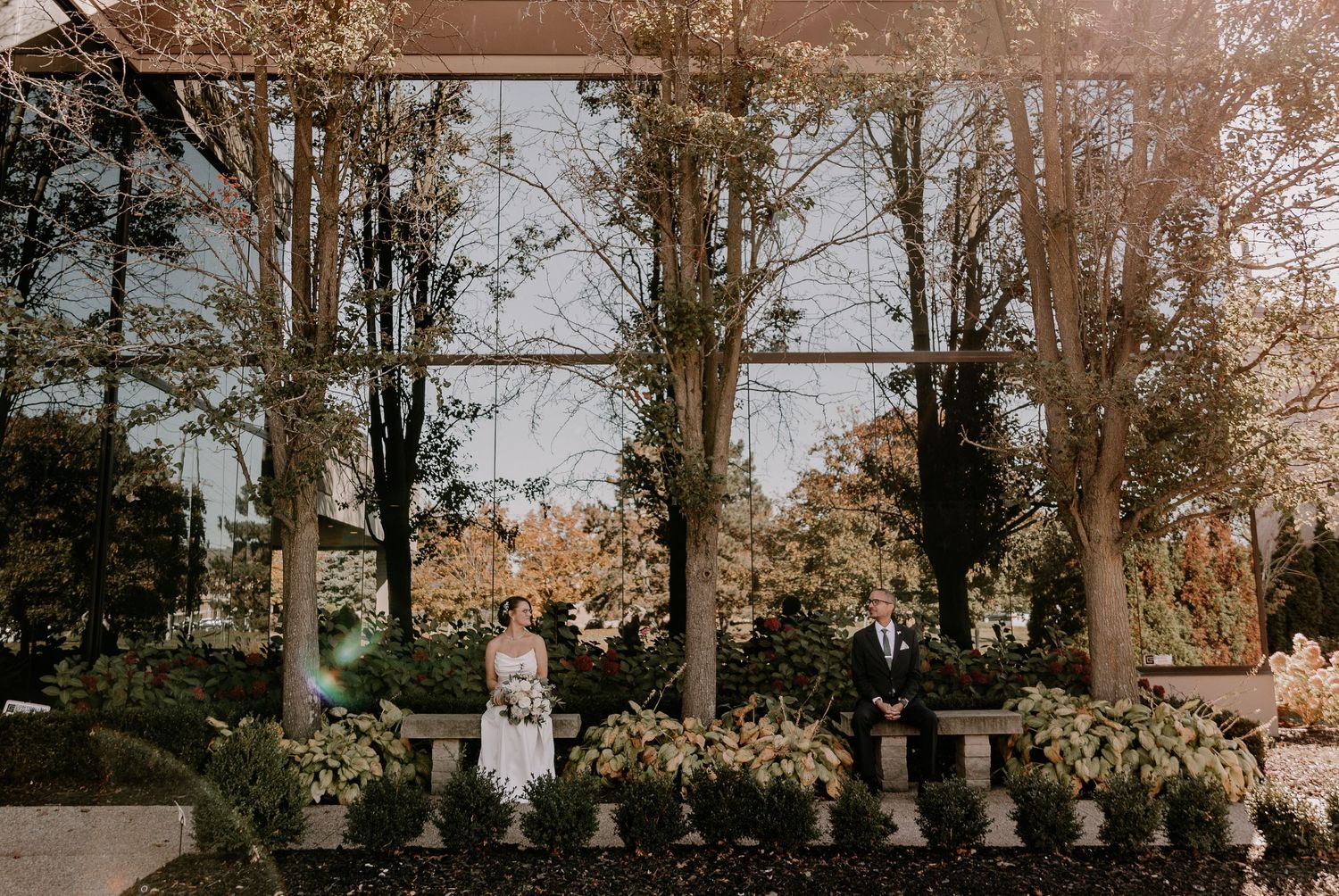 A series of outdoor wedding ceremony photos showing trees and guests in a natural autumn setting.