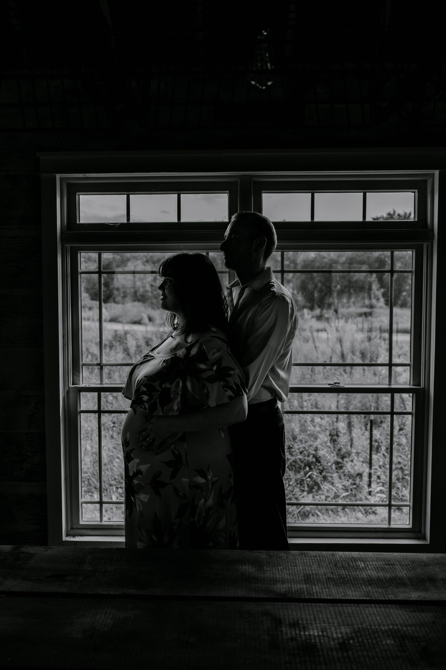 A dark silhouette stands by a window in a dramatic sequence of four black and white photos showing evolving poses.