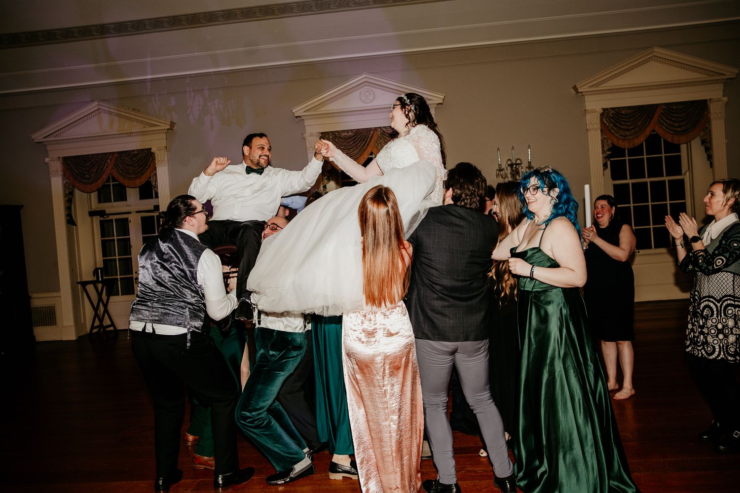 Wedding reception dance floor filled with celebratory moments and emerald green attire.