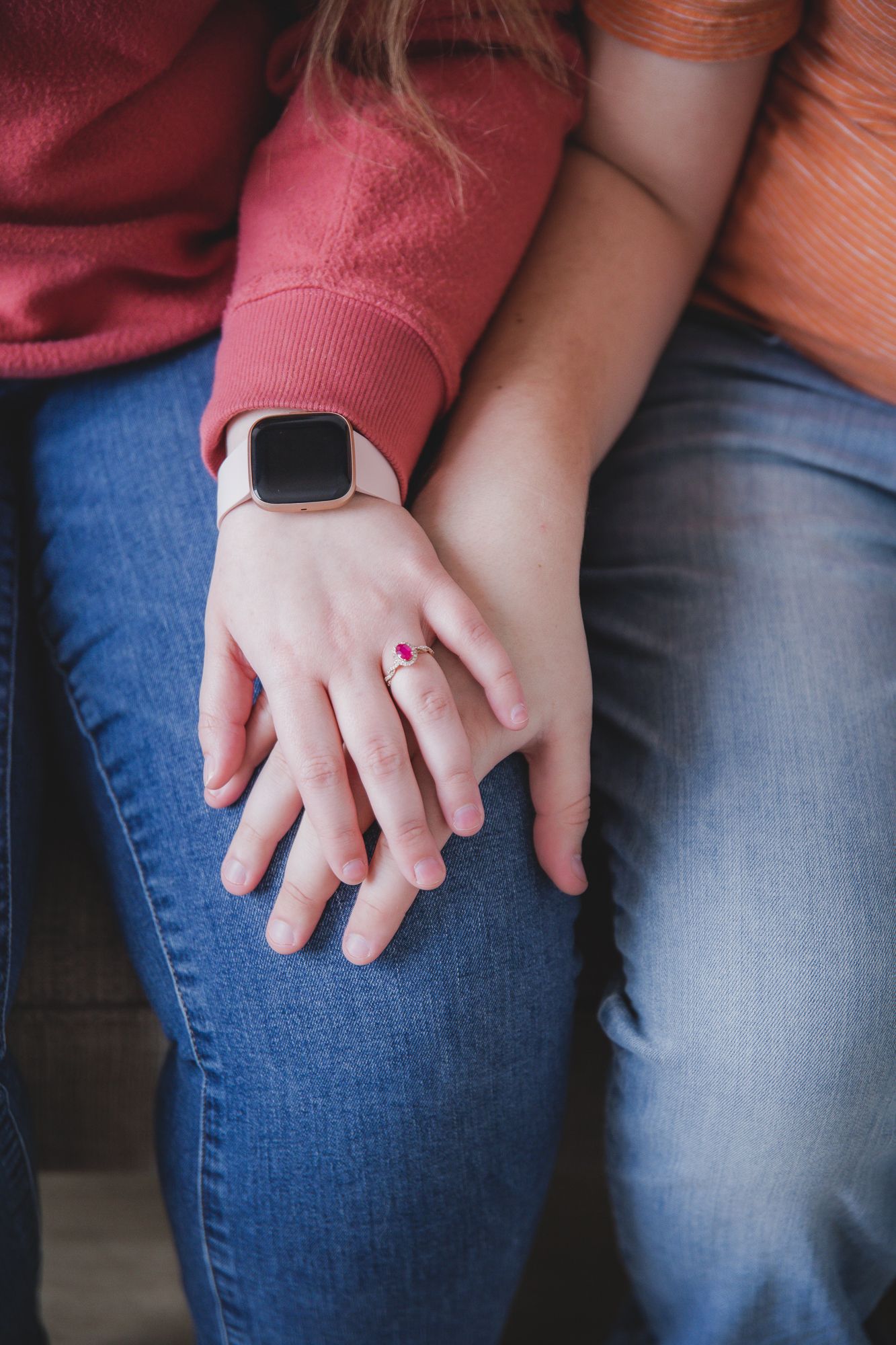 Close-up of hands holding each other against denim jeans background.