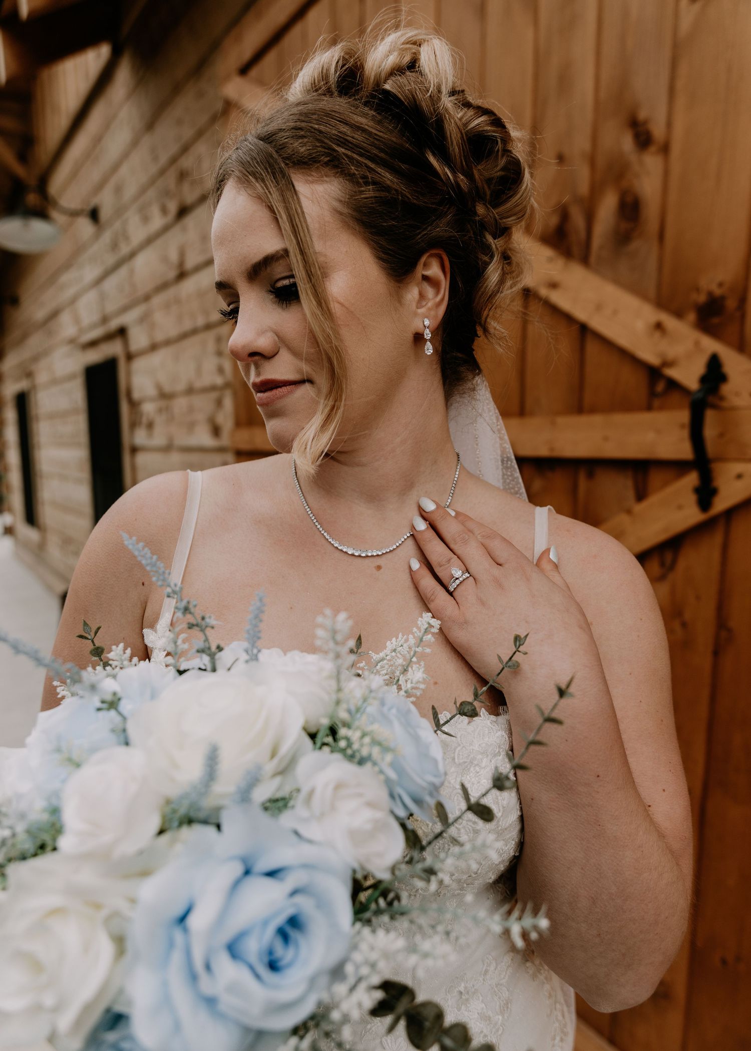 Wedding bouquet featuring light blue roses and white flowers against a wooden backdrop.