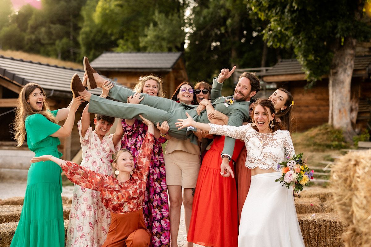 Wedding party celebrating with joyful group pose outdoors.