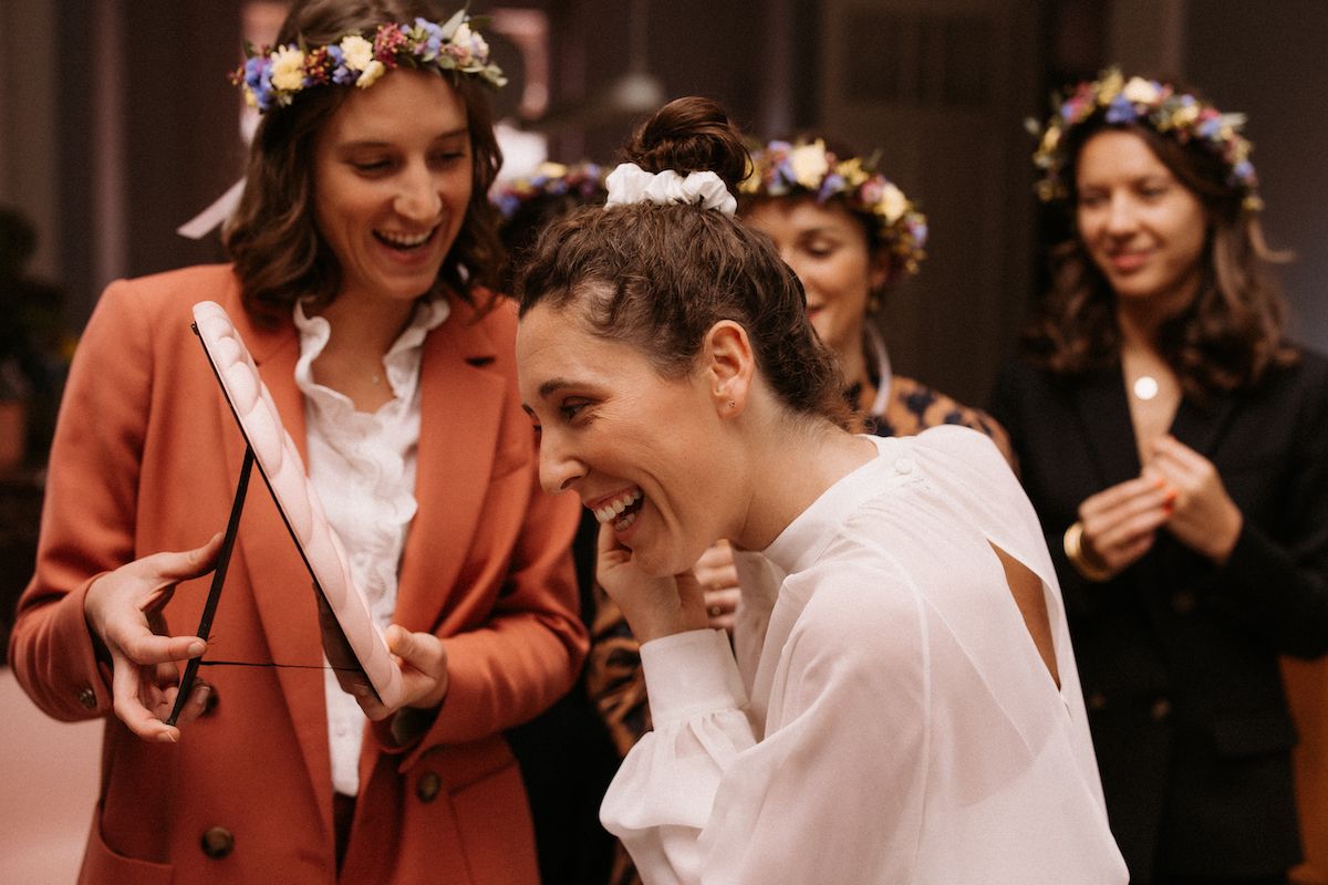 Wedding celebration scene with guests in floral crowns and bright attire.