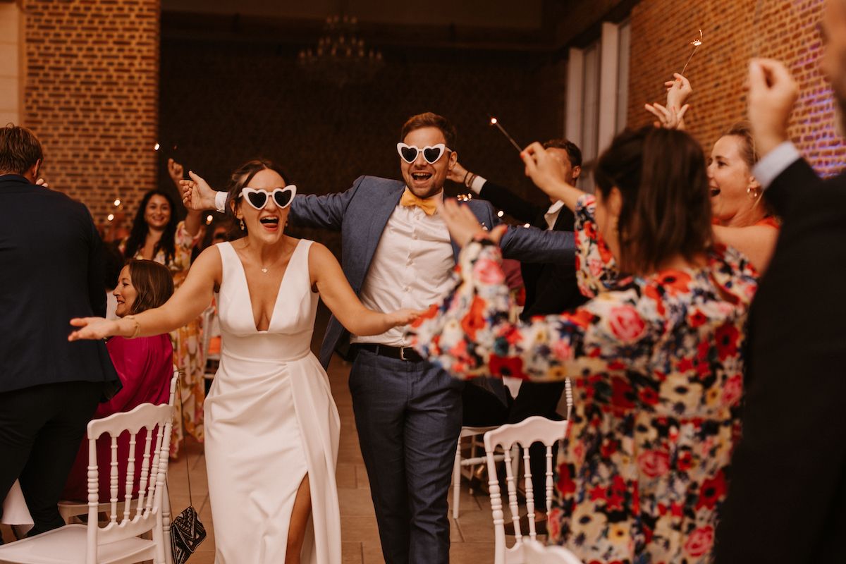 Wedding reception dance party with guests in festive attire.