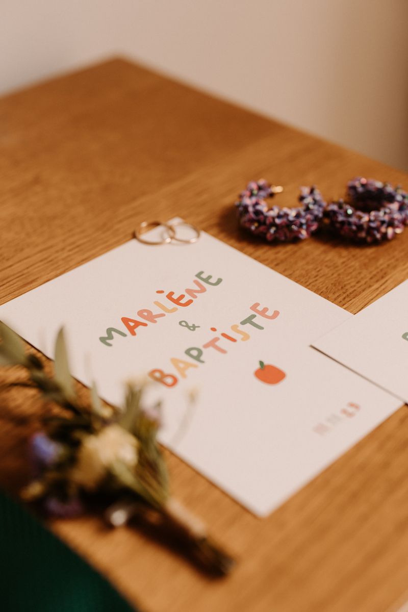 Wedding invitation with chocolate donuts on a wooden table.