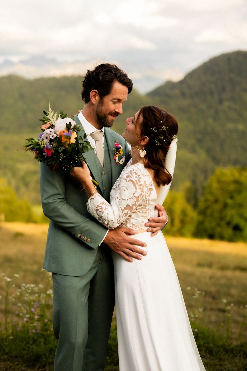 Wedding portrait with mountain backdrop and sage green suit.