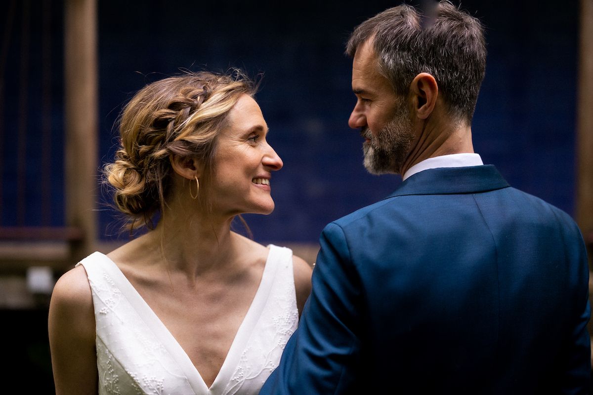 A romantic moment between newlyweds in elegant wedding attire.